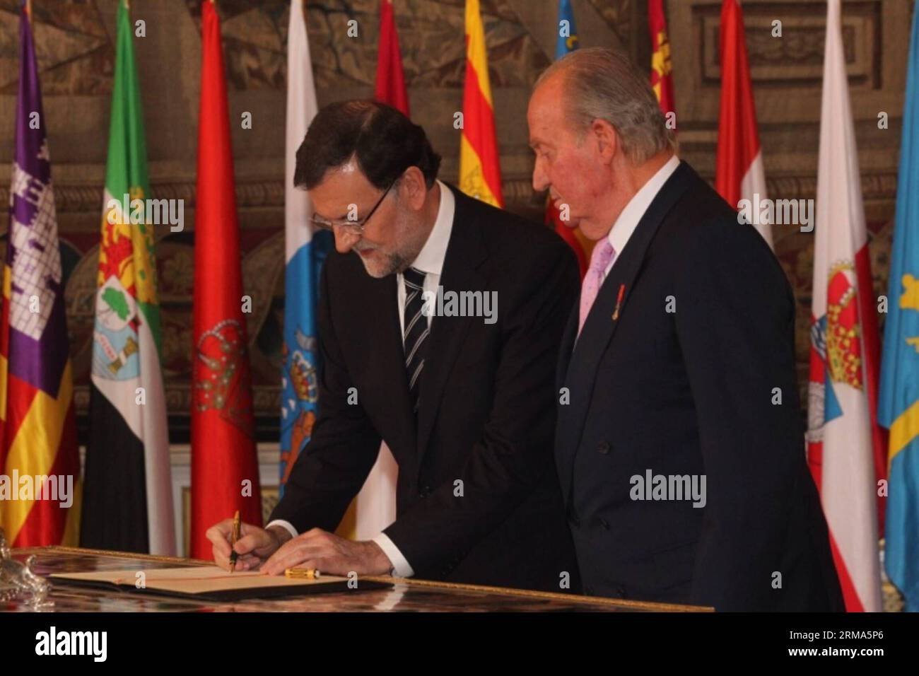 Spain s Prime Minister Mariano Rajoy (L), with the King Juan Carlos I de Borbon of Spain aside, signs the law on the king s abdication at the Royal Palace of Madrid in Madrid, June 18, 2014. The King signed on Wednesday the law on his abdication in order to give the crown to his son Felipe de Borbon, who will be King of Spain at Wednesday midnight. (Xinhua) SPAIN-MADRID-KING-ABDICATION BILL-SIGNMENT PUBLICATIONxNOTxINxCHN   Spain S Prime Ministers Mariano Rajoy l With The King Juan Carlos I de Borbon of Spain ASIDE Signs The Law ON The King S abdication AT The Royal Palace of Madrid in Madrid Stock Photo