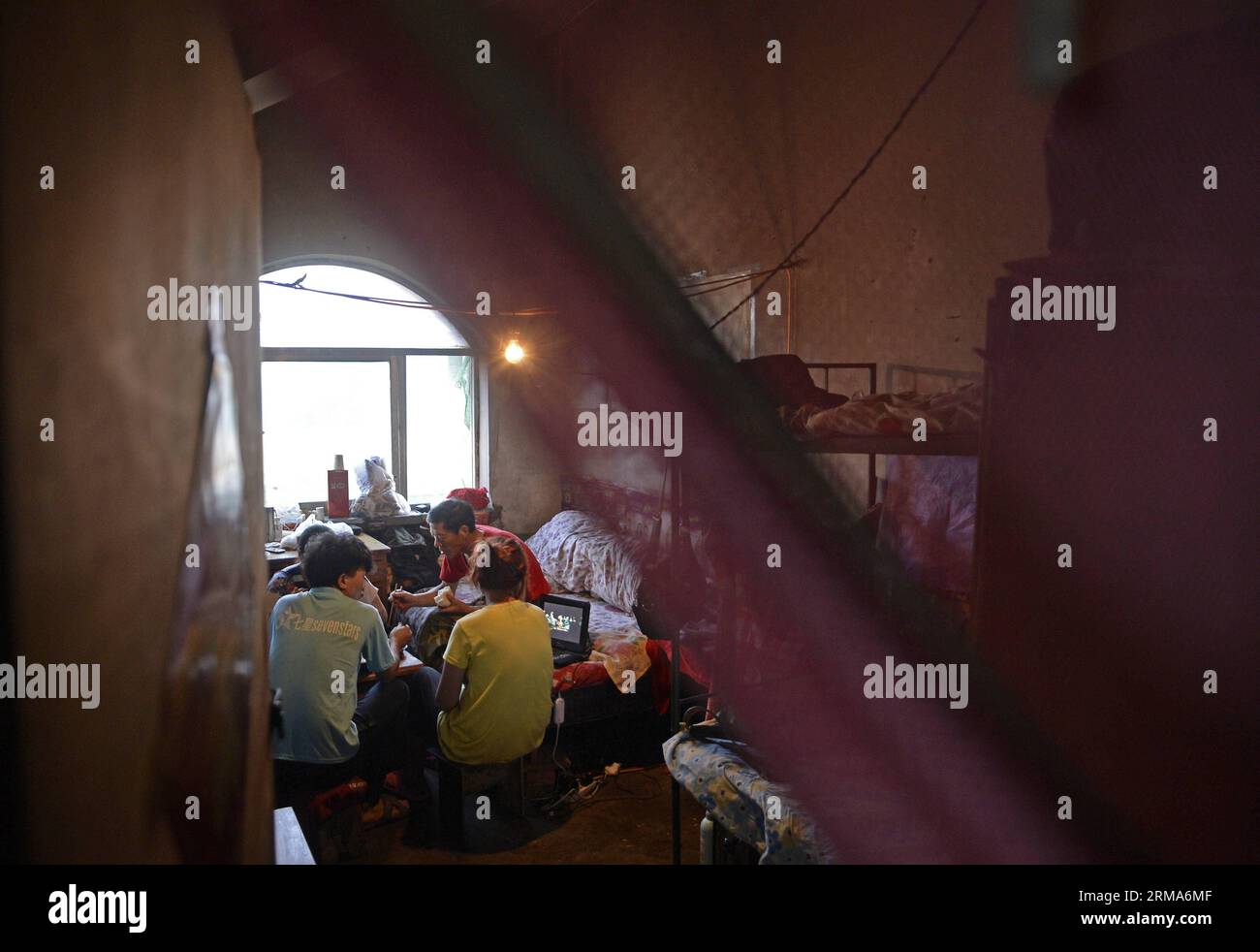 (140620) -- YINCHUAN, June 20, 2014 (Xinhua) -- A family has supper in the villa areas of Wulitai new village in Yinchuan, northwest China s Ningxia Hui Autonomous Region, June 10, 2014. There are over 30 villas in Wulitai new village with one third uncompleted due to the default of construction payments. Those villas are now rent out to migrant workers. A 200-square-meter villa was seperated into several rooms, and the rent of each one is about 300 yuan (about 48.18 U.S.dollars). For migrant workers who have no access to cheap bungalows or can t afford apartments, such room is a good residenc Stock Photo