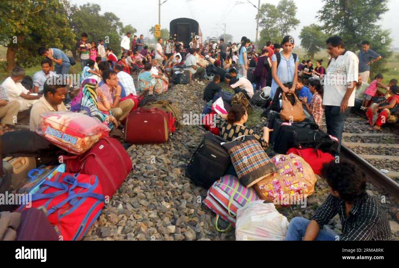 (140625) -- CHHAPRA, June 25, 2014 (Xinhua) -- Distress passengers sit on the railway track after a train known as Rajdhani Express derailed near Chhapra town, some 75 km from the state capital of Bihar Ptana, India, June 25, 2014. At least four people were killed after an express passenger train from the Indian capital to the northeast city of Dibrugarh derailed in the eastern state of Bihar early Wednesday morning, said officials and local media reports. (Xinhua/Stringer) INDIA-CHHAPRA-TRAIN DERAILMENT PUBLICATIONxNOTxINxCHN   June 25 2014 XINHUA Distress Passengers Sit ON The Railway Track Stock Photo