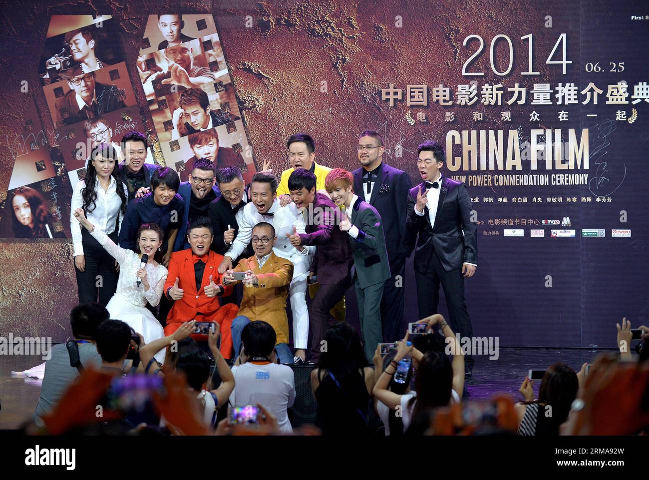 Guests and anchormen pose for photos during China Film New Power Commendation Ceremony in Beijing, capital of China, June 25, 2014. Ten young directors brought their new works to the ceremony. (Xinhua/Li Xin) (lfj) CHINA-BEIJING-CHINA FILM NEW POWER COMMENDATION CEREMONY (CN) PUBLICATIONxNOTxINxCHN   Guests and  Pose for Photos during China Film New Power  Ceremony in Beijing Capital of China June 25 2014 ten Young Directors BROUGHT their New Works to The Ceremony XINHUA left Xin  China Beijing China Film New Power  Ceremony CN PUBLICATIONxNOTxINxCHN Stock Photo