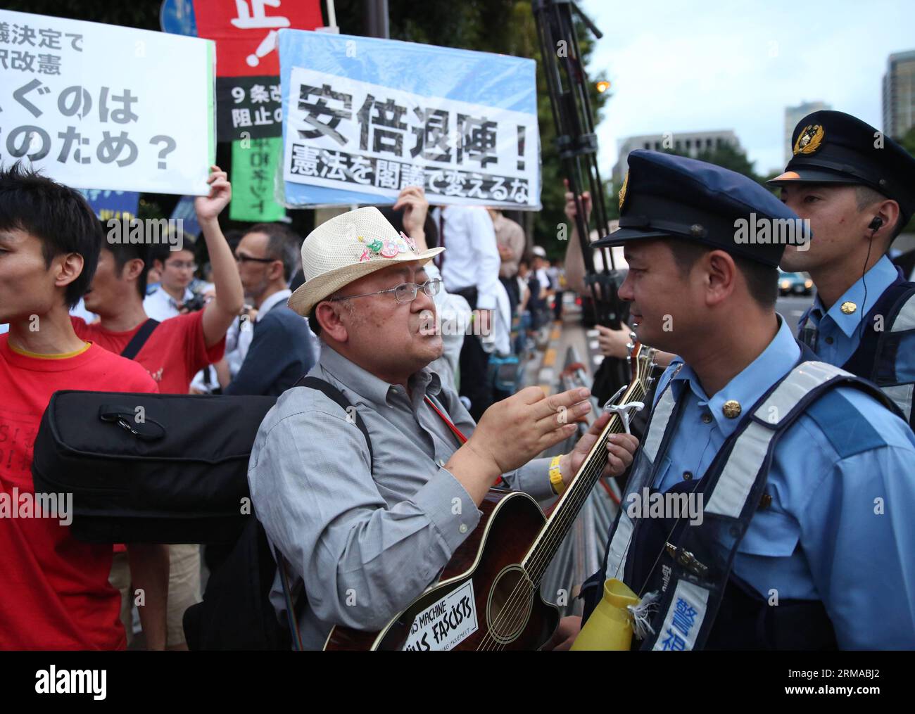 (140630) -- TOKYO, June 30, 2014 (Xinhua) -- People confront police during a rally to protest against the attempt to exercise the rights to collective self-defense in front of the Prime Minister s official residence in Tokyo, Japan, June 30, 2014. Thousands of Japanese people gathered here Monday, protesting against Japanese Prime Minister Shinzo Abe s attempt to allow Japan s Self-Defense Forces (SDF) to exercise the rights to collective self-defense. The Japanese government sought to get a green light from the Cabinet on July 1 for a resolution that will allow Japan to exercise collective se Stock Photo