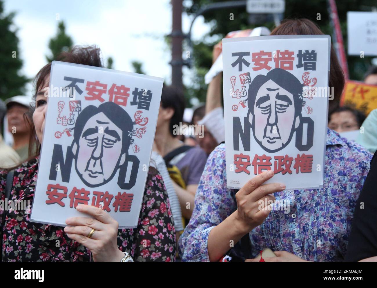 (140630) -- TOKYO, June 30, 2014 (Xinhua) -- People attend a rally to protest against the attempt to exercise the rights to collective self-defense in front of the Prime Minister s official residence in Tokyo, Japan, June 30, 2014. Thousands of Japanese people gathered here Monday, protesting against Japanese Prime Minister Shinzo Abe s attempt to allow Japan s Self-Defense Forces (SDF) to exercise the rights to collective self-defense. The Japanese government sought to get a green light from the Cabinet on July 1 for a resolution that will allow Japan to exercise collective self-defense right Stock Photo