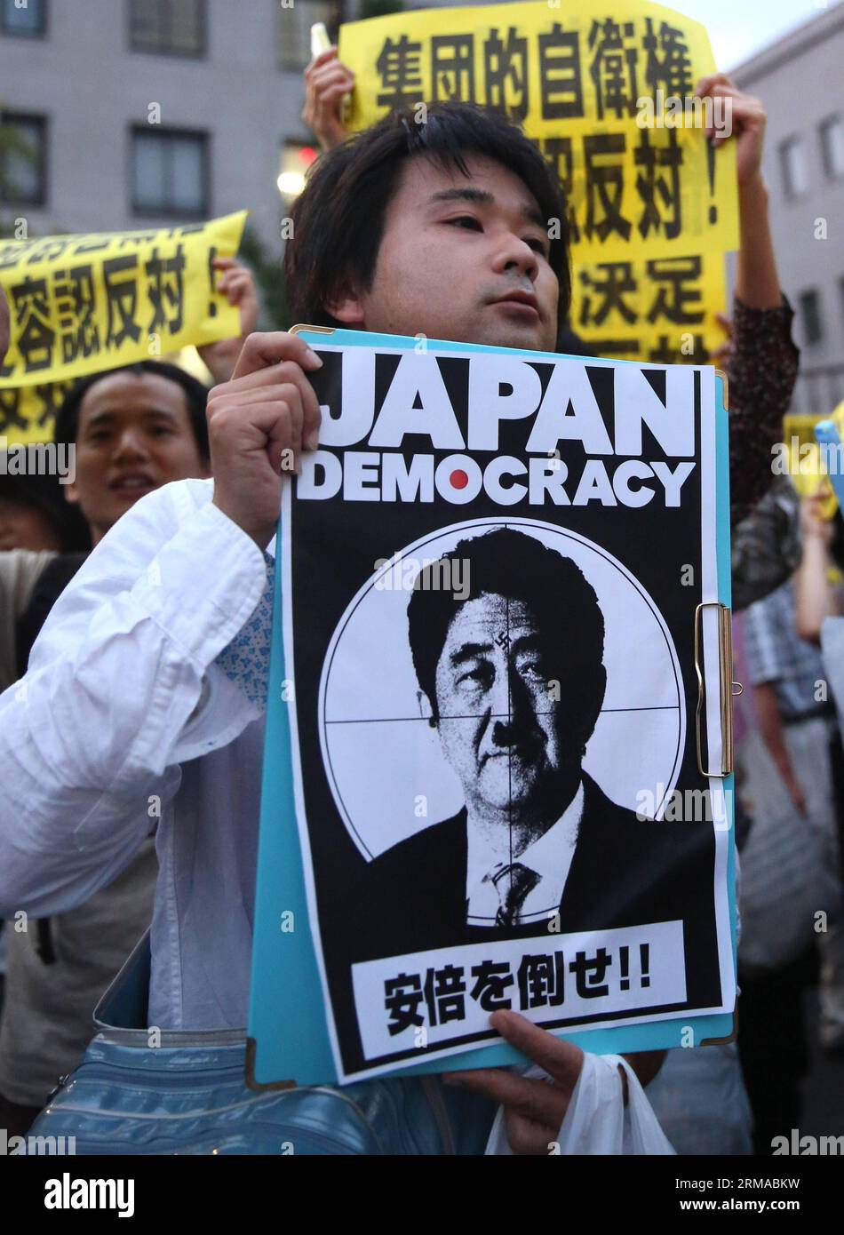 (140630) -- TOKYO, June 30, 2014 (Xinhua) -- A protester holds a caricature of Japanese Prime Minister Shinzo Abe during a rally to protest against the attempt to exercise the rights to collective self-defense in front of the Prime Minister s official residence in Tokyo, Japan, June 30, 2014. Thousands of Japanese people gathered here Monday, protesting against Japanese Prime Minister Shinzo Abe s attempt to allow Japan s Self-Defense Forces (SDF) to exercise the rights to collective self-defense. The Japanese government sought to get a green light from the Cabinet on July 1 for a resolution t Stock Photo