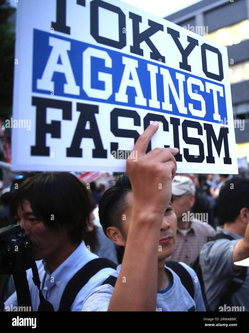 (140630) -- TOKYO, June 30, 2014 (Xinhua) -- A protester holds a banner during a rally to protest against the attempt to exercise the rights to collective self-defense in front of the Prime Minister s official residence in Tokyo, Japan, June 30, 2014. Thousands of Japanese people gathered here Monday, protesting against Japanese Prime Minister Shinzo Abe s attempt to allow Japan s Self-Defense Forces (SDF) to exercise the rights to collective self-defense. The Japanese government sought to get a green light from the Cabinet on July 1 for a resolution that will allow Japan to exercise collectiv Stock Photo