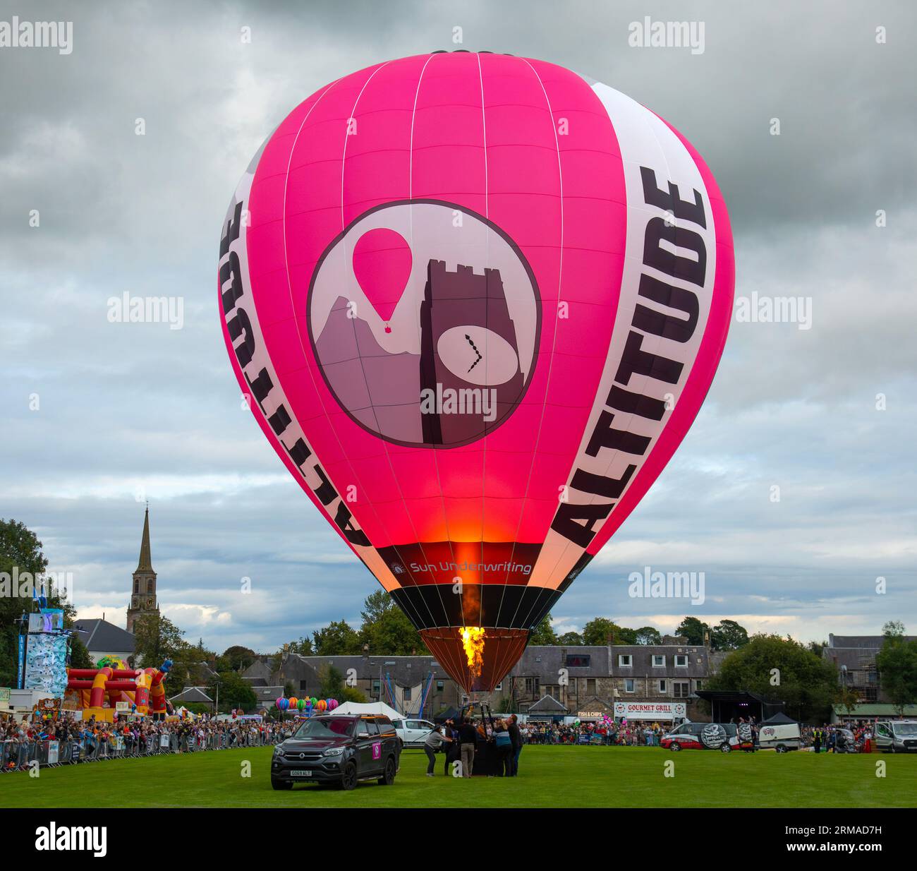 People holding onto a hot-air balloon which is being inflated ready for flight during the Strathaven Balloon Festival 2023 in Strathaven, Scotland. Stock Photo