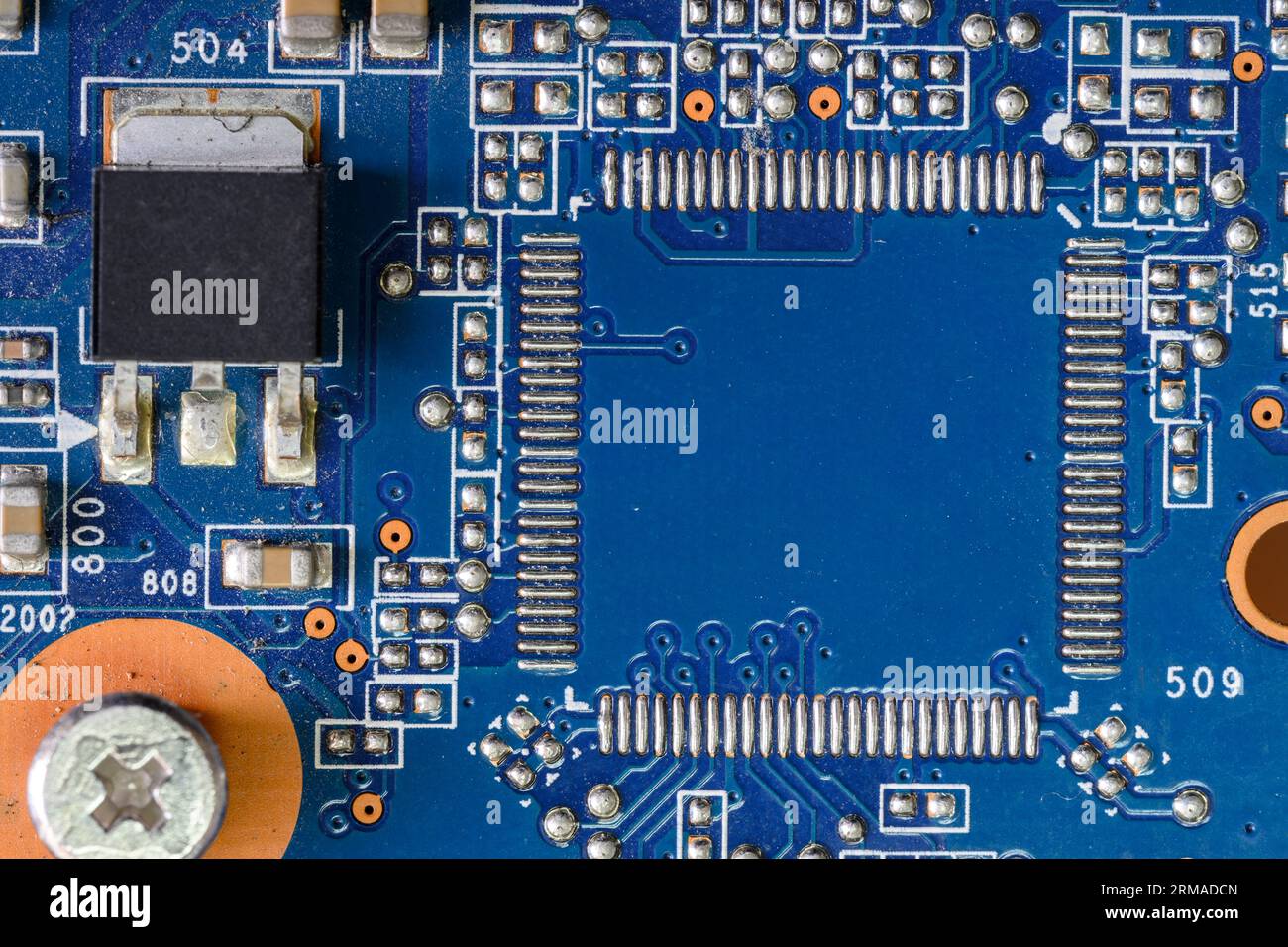 Computer Board Capacitor A fragment of a blue computer board with capacitors and desoldering for ...