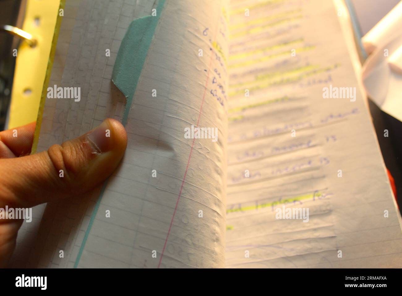 A photo of a school student's hand scrolling through a binder of paper