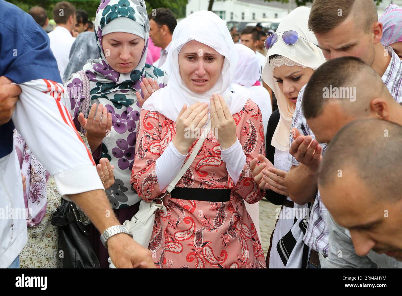 A young woman mourns for her father during a funeral in Potocari, near Srebrenica, Bosnia and Herzegovina, July 11, 2014. The funeral of 175 recently identified victims was held here Friday to commemorate the 19th anniversary of the Srebrenica massacre. Some 7,000 Muslim men and boys were massacred in and near Srebrenica by Bosnian Serb forces in July 1995, the worst massacre in Europe since the end of World War II. (Xinhua/Haris Memija) (zjl) BIH-SREBRENICA-MASSACRE-19TH ANIVERSARY PUBLICATIONxNOTxINxCHN   a Young Woman  for her Father during a Funeral in  Near Srebrenica Bosnia and Herzegovi Stock Photo