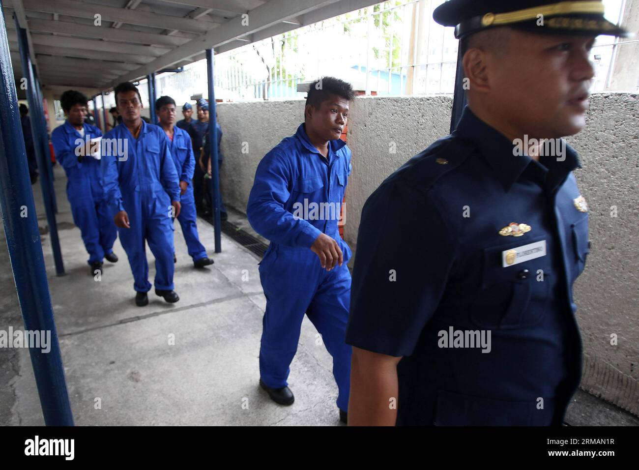 (140717) -- MANILA, July 17, 2014 (Xinhua) -- A member of the Philippine Coast Guard (PCG) leads the four rescued Filipino fishermen inside the PCG Headquarters in Manila, the Philippines, on July 17, 2014. The crew of Chinese vessel MV Pacific Pioneer, which came from Hong Kong of China, rescued the four Filipino fishermen who were in the sea for two days after their vessel was submerged in the strong wind brought by typhoon Rammasun. (Xinhua/Rouelle Umali) PHILIPPINES-MANILA-RESCUED FISHERMEN PUBLICATIONxNOTxINxCHN   Manila July 17 2014 XINHUA a member of The Philippine Coast Guard PCG leads Stock Photo