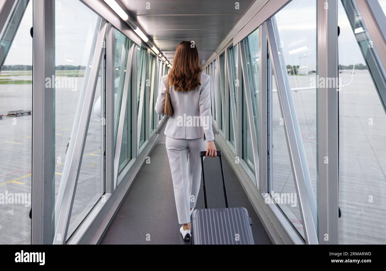 Businesswoman boarding the plane with carryon Stock Photo Alamy