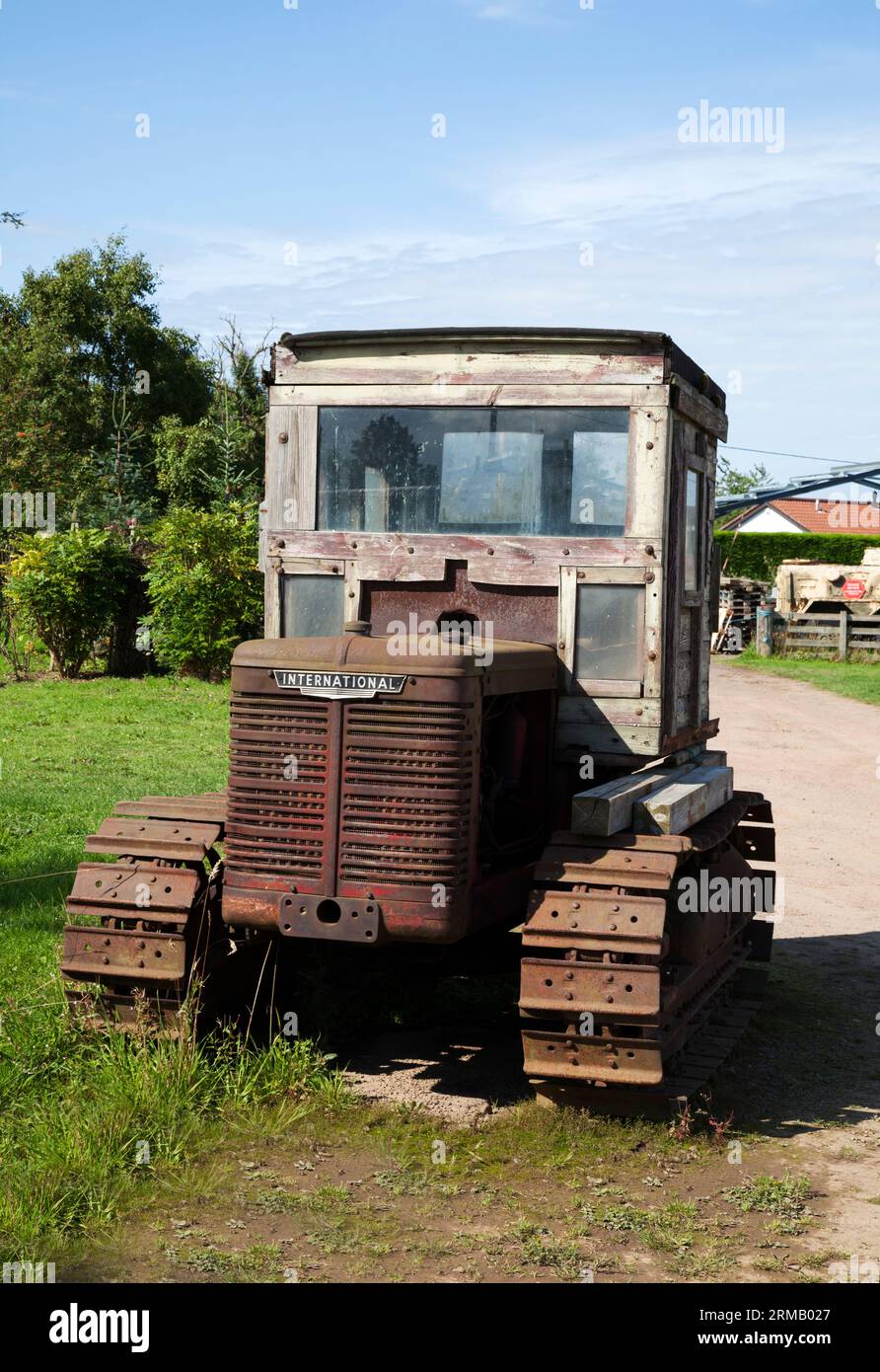 Rusting International caterpillar tractor with wooden cab. Stock Photo