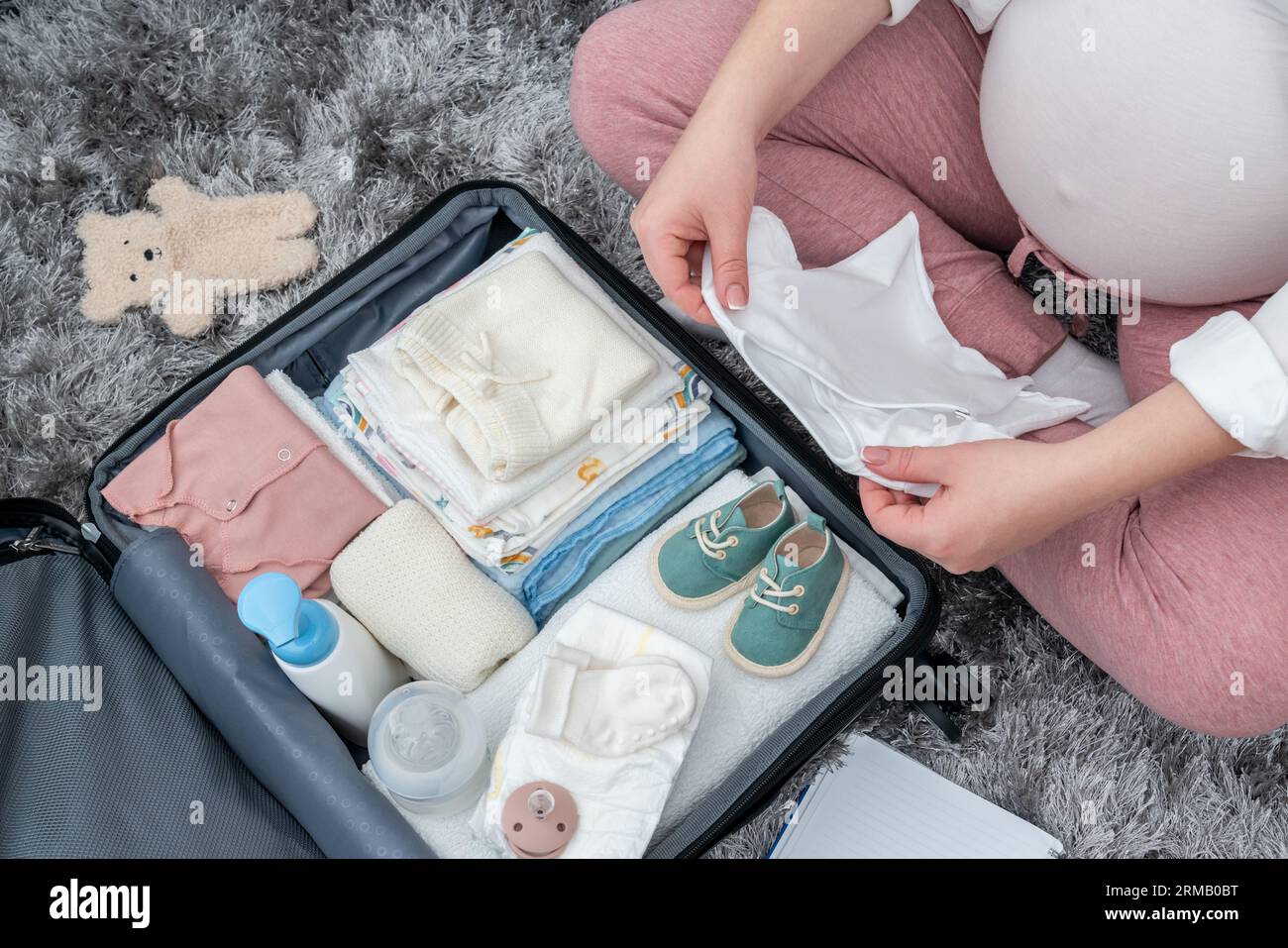Capturing top view essence of an expectant woman on the floor, packing