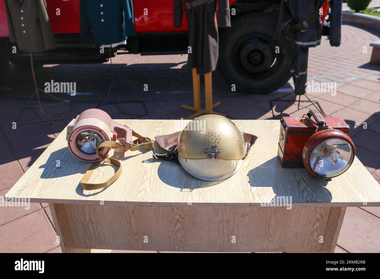 Old fire equipment, fire bronze protective helmet and miner's lanterns on the table. Stock Photo