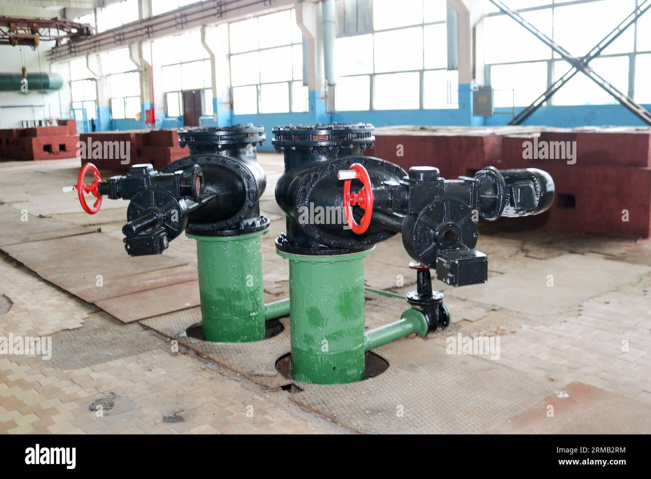 A large black metal iron gate valve with an electric drive at an