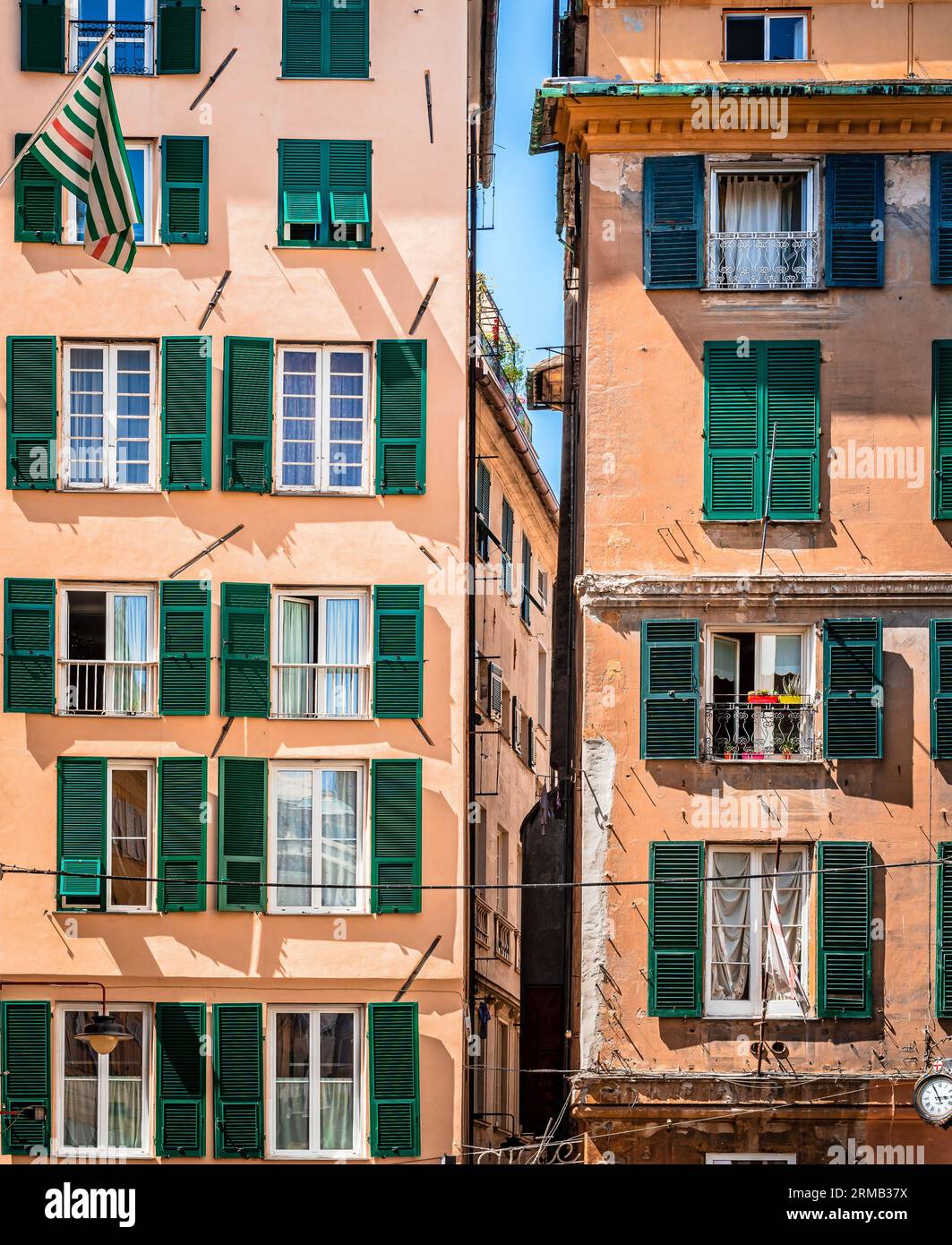 Facades of two similar residential building in Genoa downtown, Italy. A renovated one on the left and an old one on the right. Stock Photo