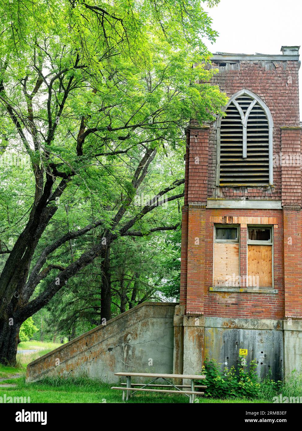 Old brick schoolhouse abandon with window boarded up Stock Photo
