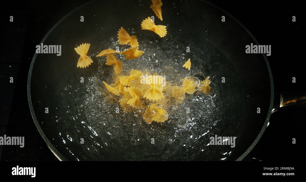 Pasta falling into boiling water Stock Photo Alamy