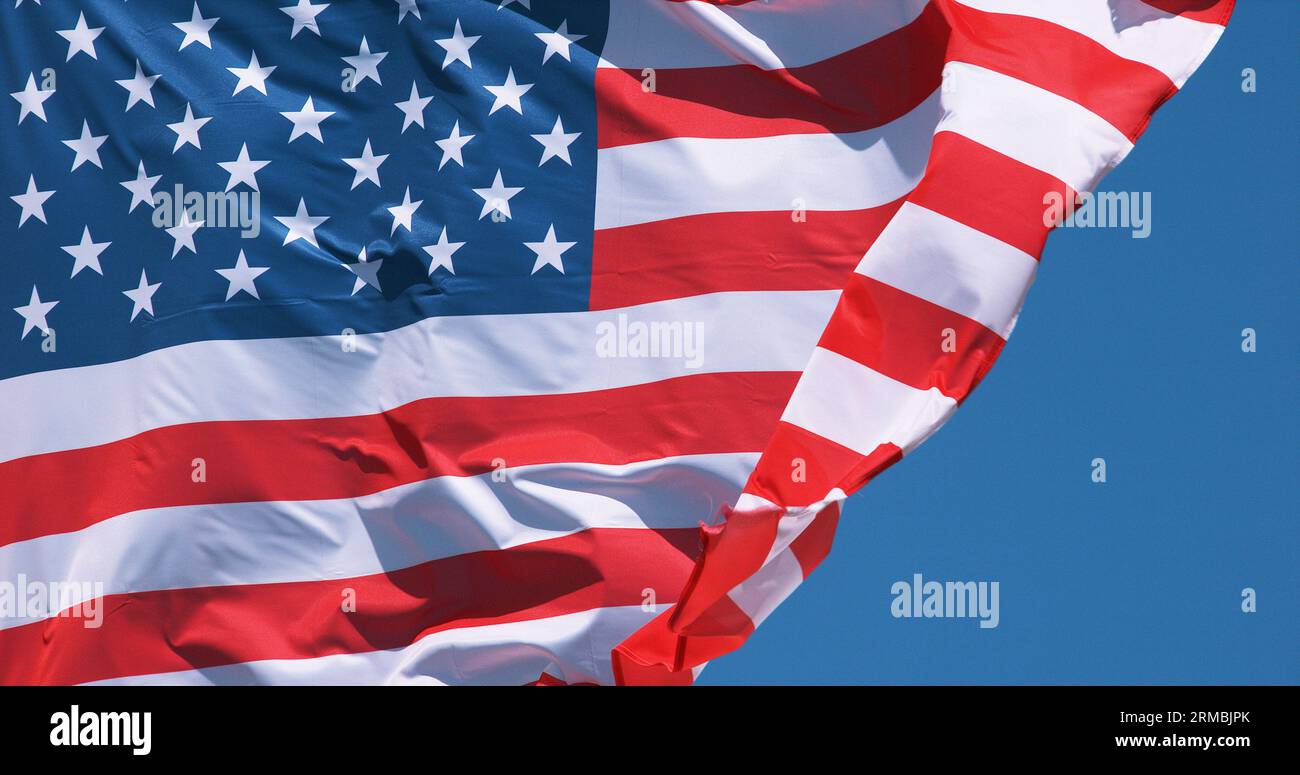 American Flag Waving in the Wind against blue sky Stock Photo - Alamy