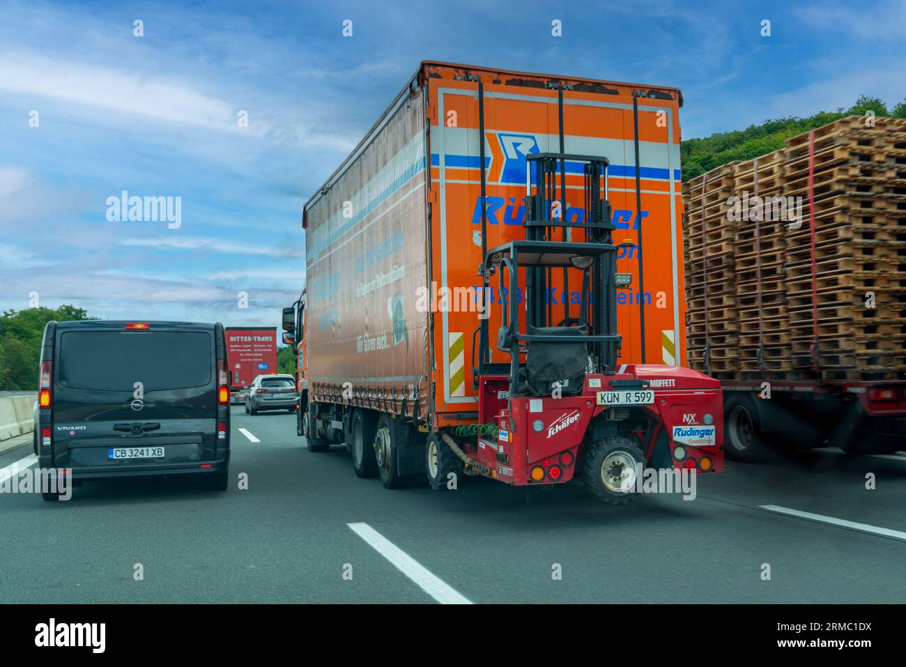 Germany-August 01, 2023: Truck-mounted forklifts, also known as piggyback forklifts driving on heavy traffic on motorway Stock Photo