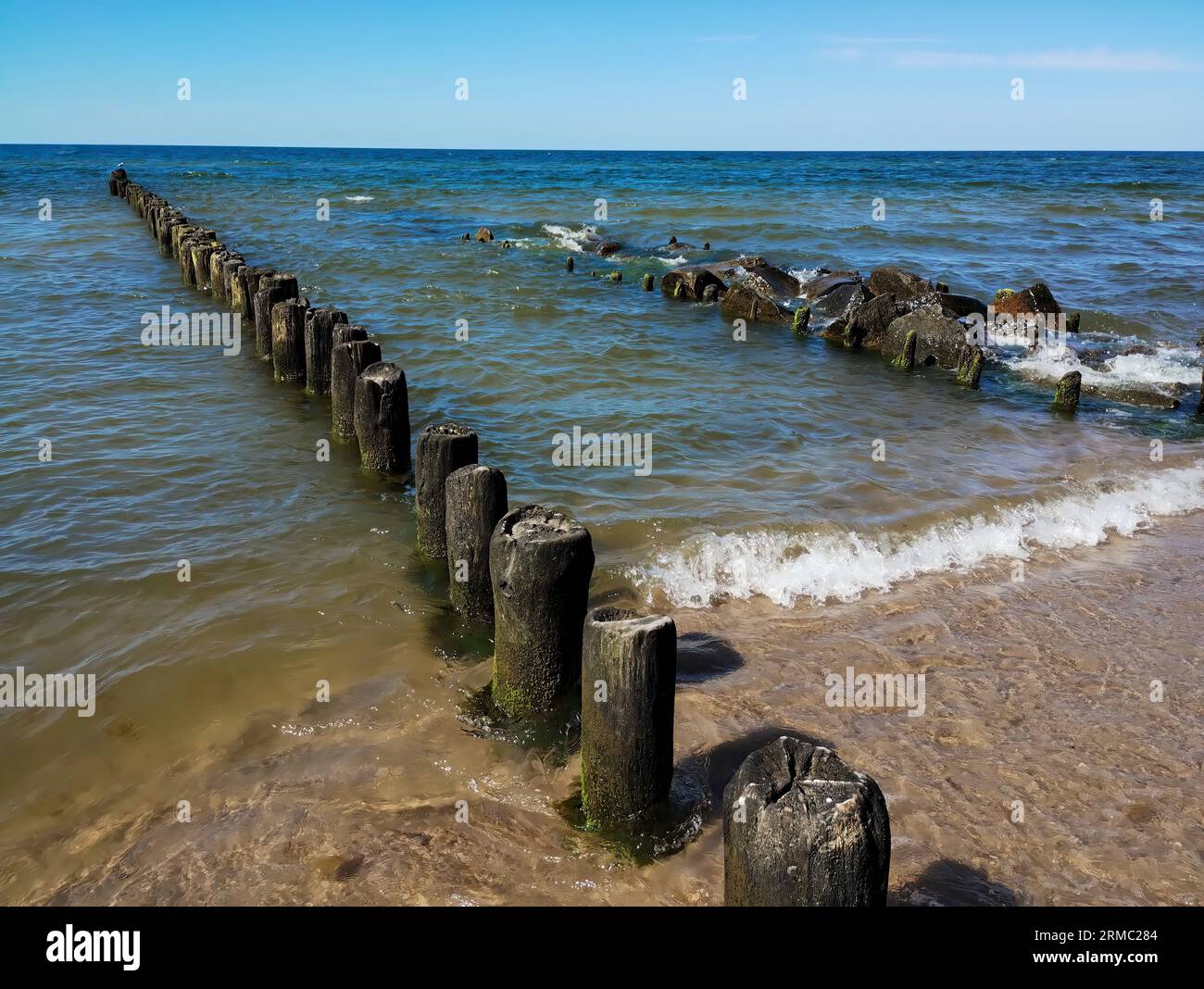 breakwater and rocks - wooden breakwater piles and rocks - marine horizontal wallpaper Stock Photo