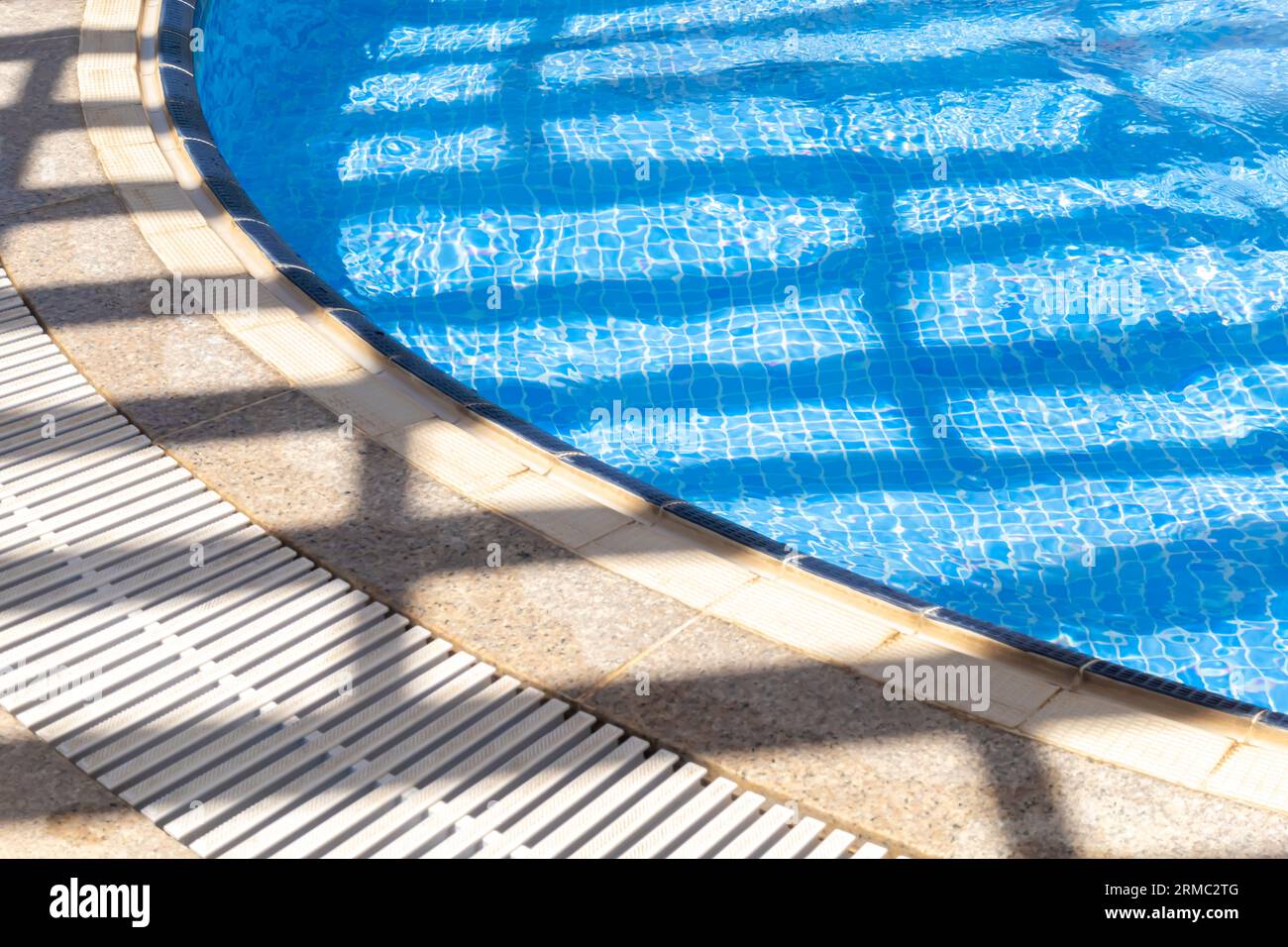 Light and shadows grid on water in outdoor pool Stock Photo