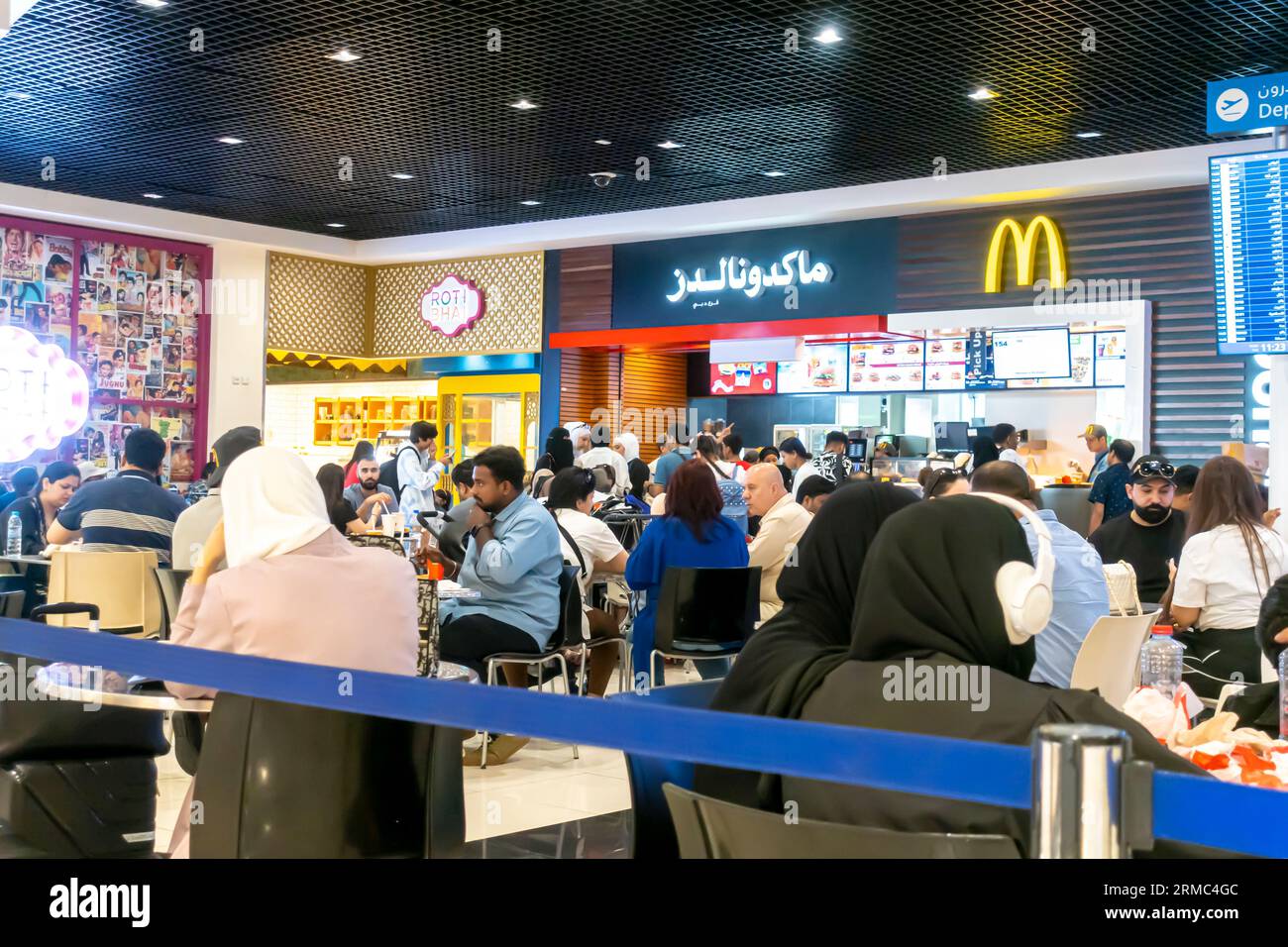 McDonalds Dubai airport cafe. McDonalds Dubai airport people tourists eating Stock Photo