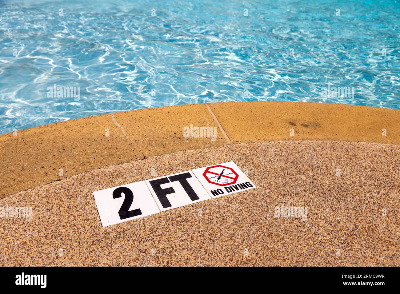 Edge of swimming pool with NO Diving warning sign and 2 ft depth marker