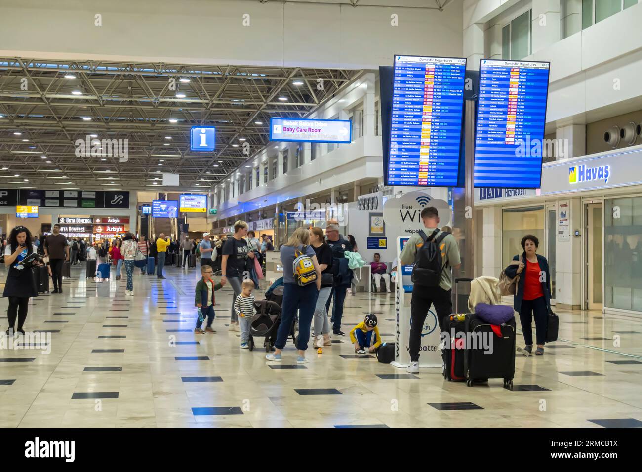 Antalya airport terminal. Tourists in front of departures screen. People at airport Antalya Turkey Stock Photo