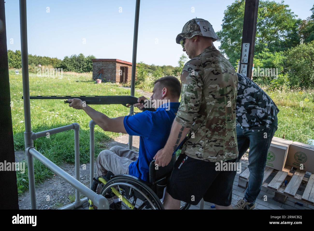 Lviv, Ukraine. 26th Aug, 2023. A man in a wheelchair holds a rifle in his  hands and aims at a target. The military participates in the Defender of  Ukraine Cup in bench