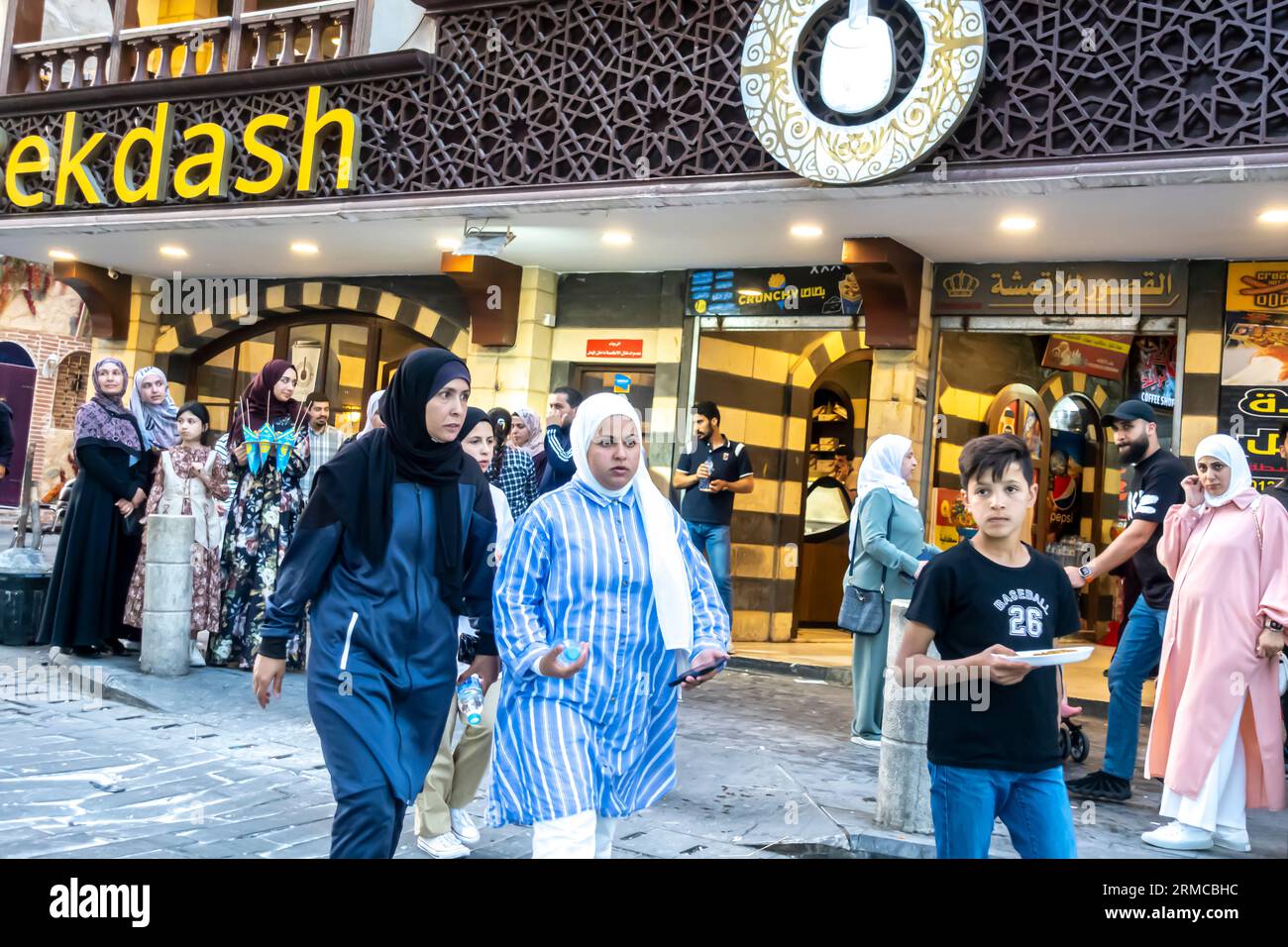 People passing by Bekdash ice cream downtown store Amman Jordan. Women