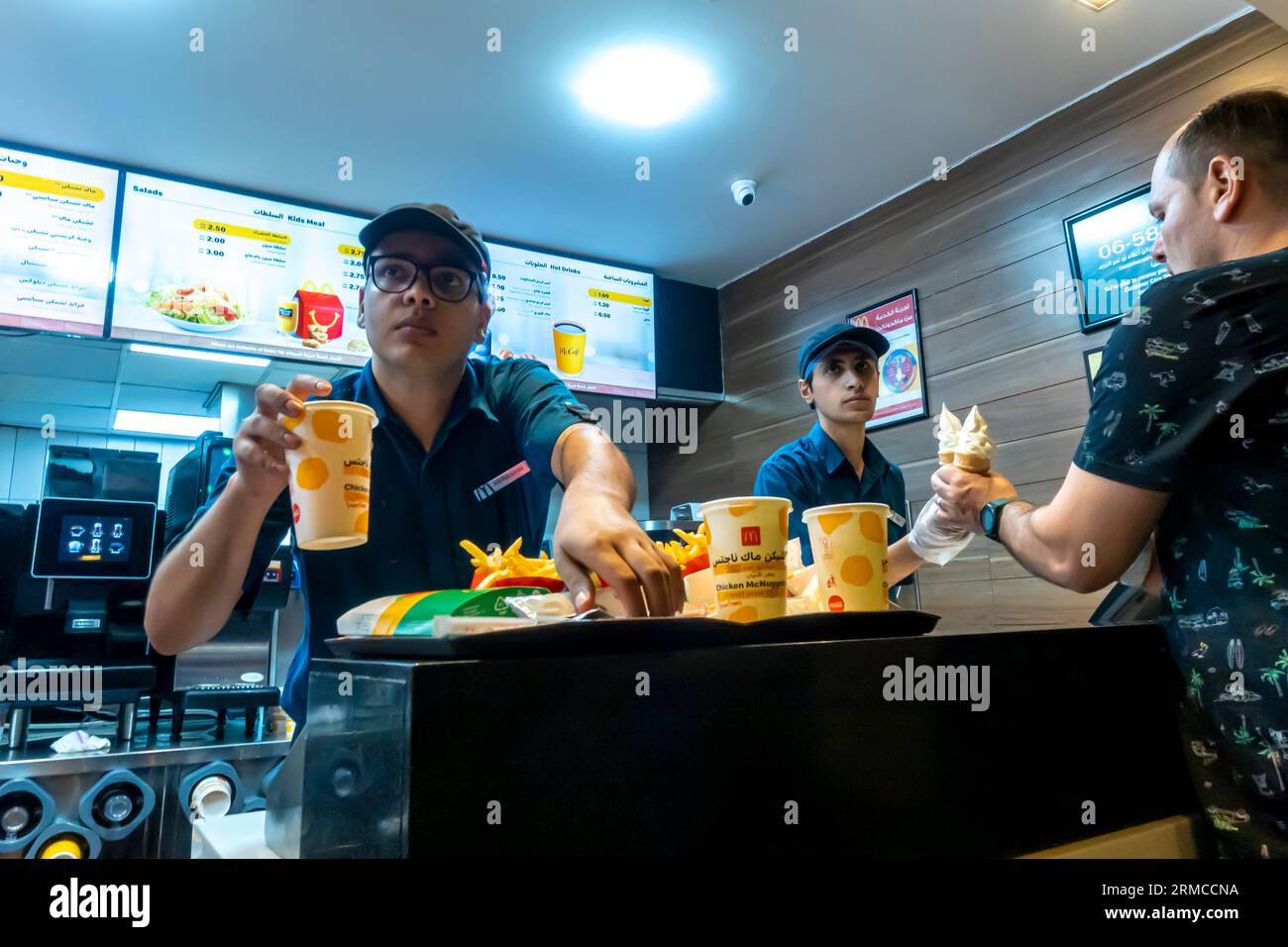 Male employee delivering McDonalds order in McDonalds Aqaba restaurant Jordan Stock Photo