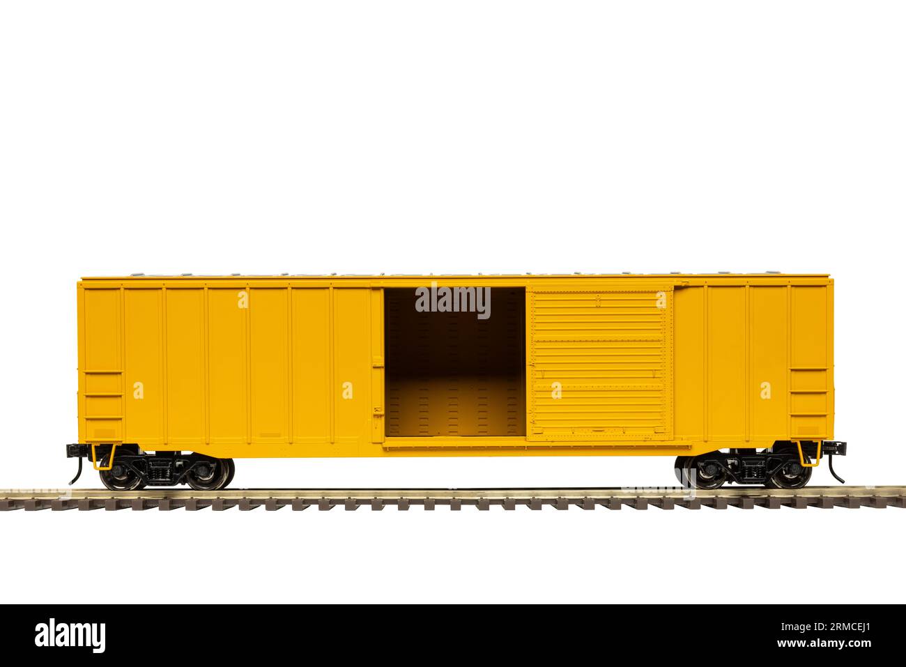 A yellow railroad boxcar with open door on railroad tack. Stock Photo