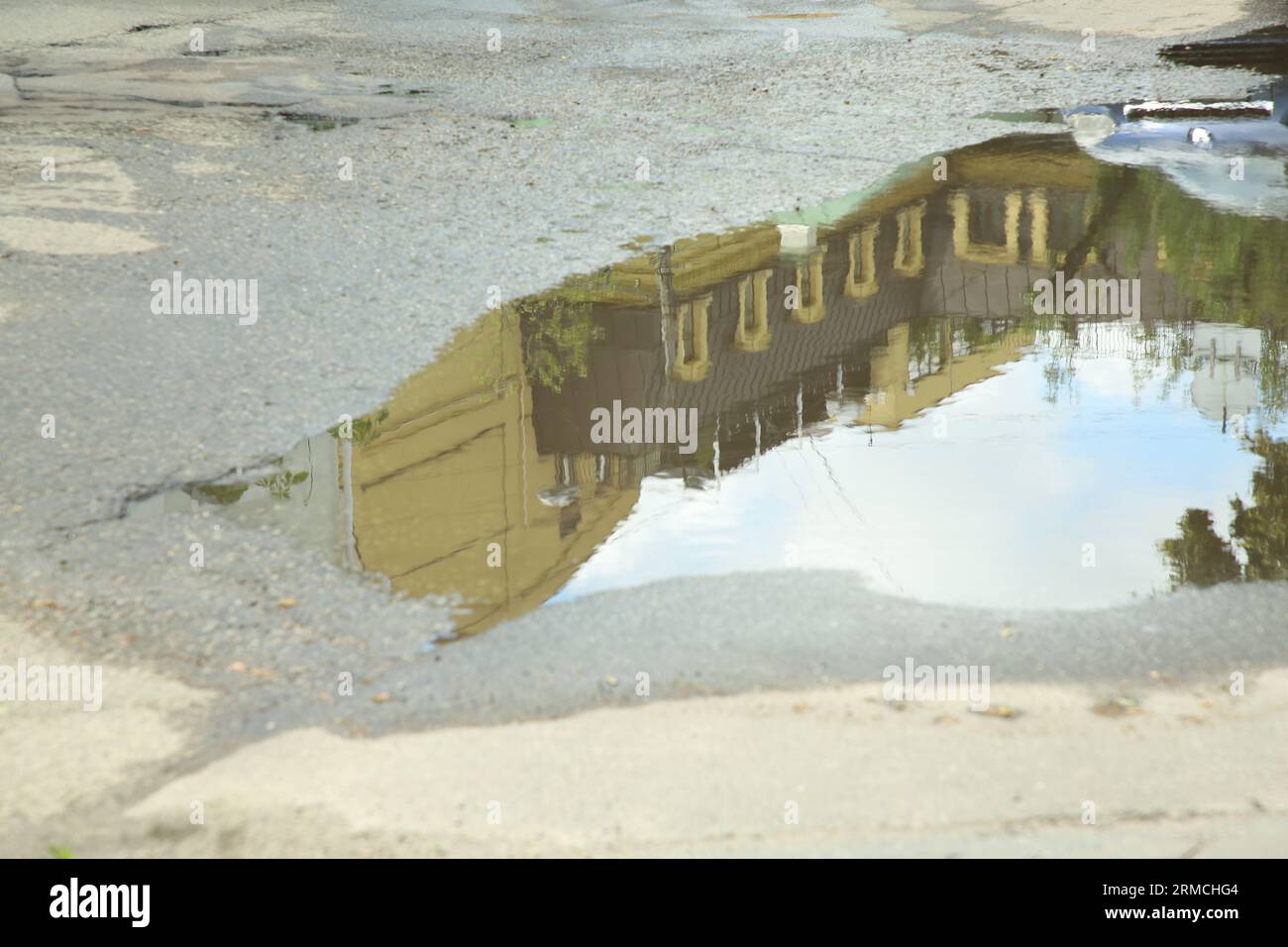 Reflection of buildings in puddle on asphalt Stock Photo - Alamy