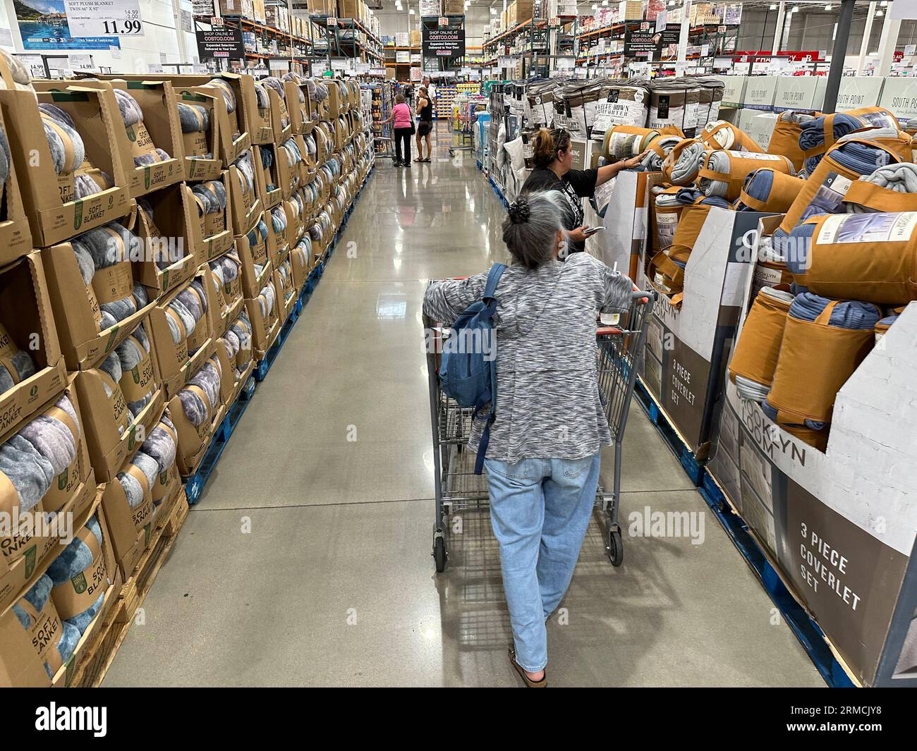 Shoppers look over blankets on sale in a Costco warehouse Thursday, Aug. 24, 2023, in Sheridan