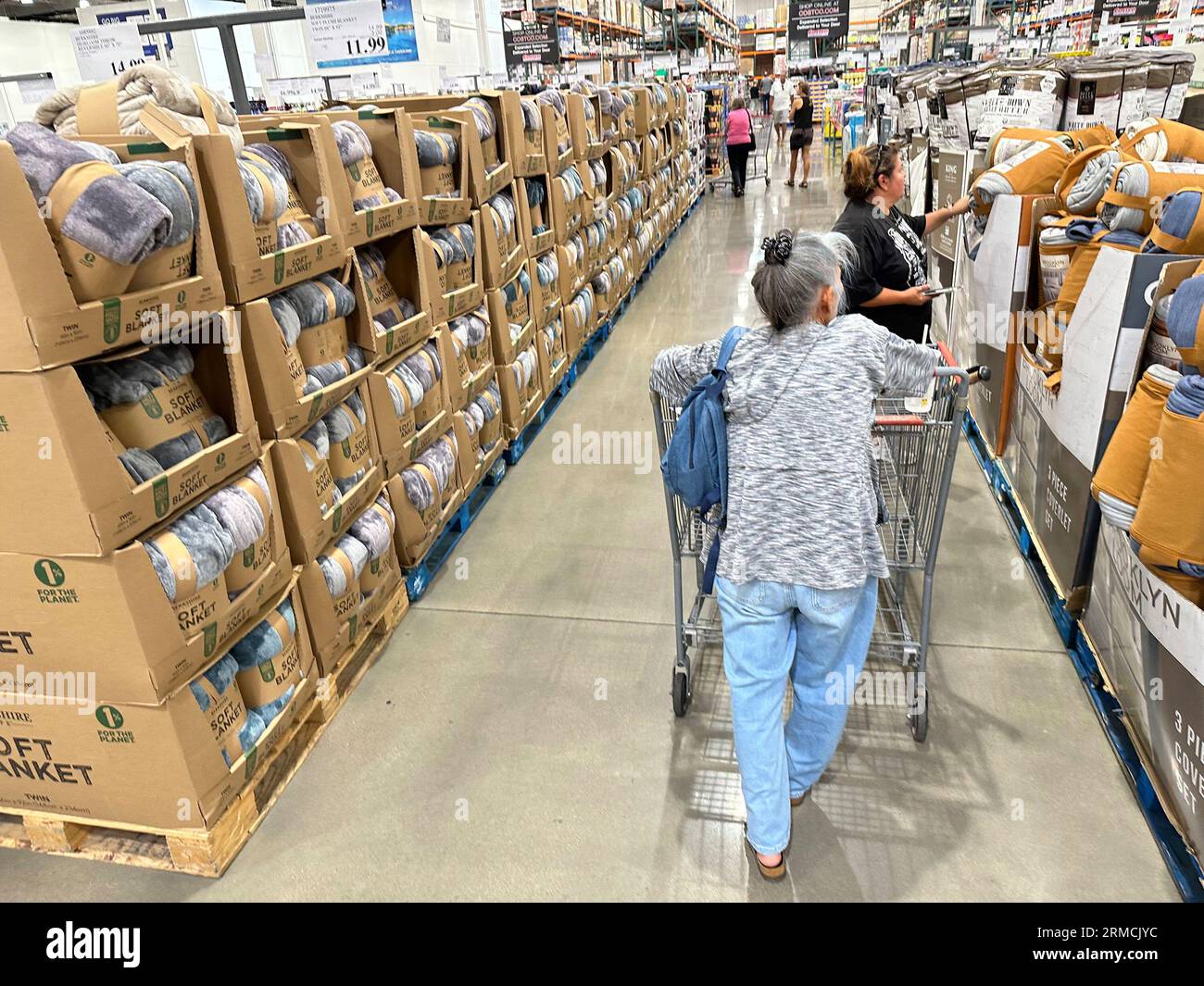 Shoppers look over blankets on sale in a Costco warehouse Thursday, Aug. 24, 2023, in Sheridan