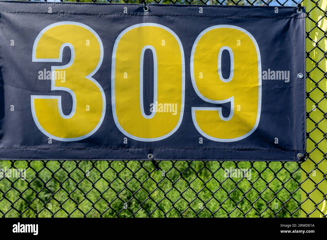 309 foot ft baseball field distance sign in yellow and black mounted on the black vinyl outfield