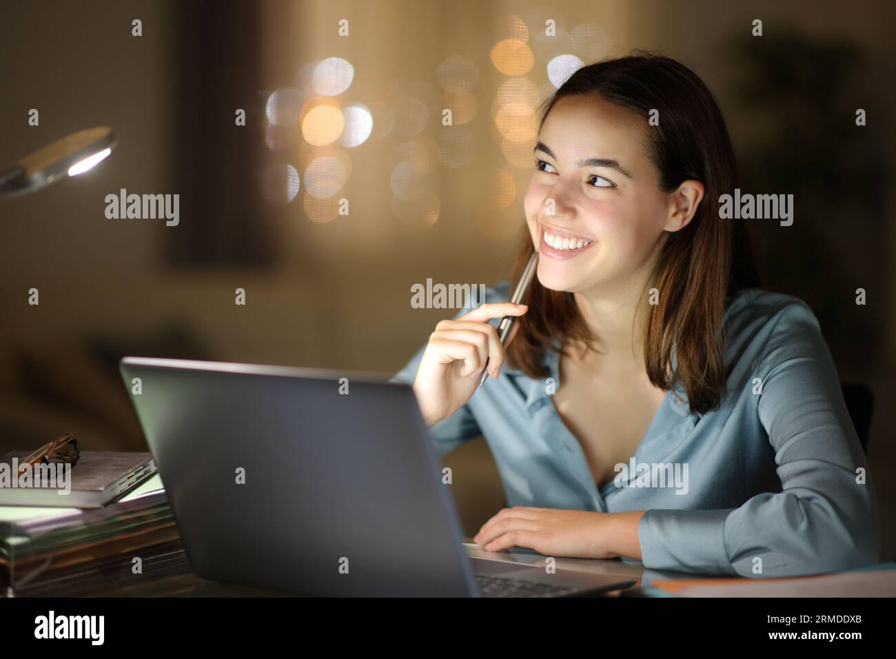 Happy entrepreneur thinking looking at side teleworking in the night at home Stock Photo