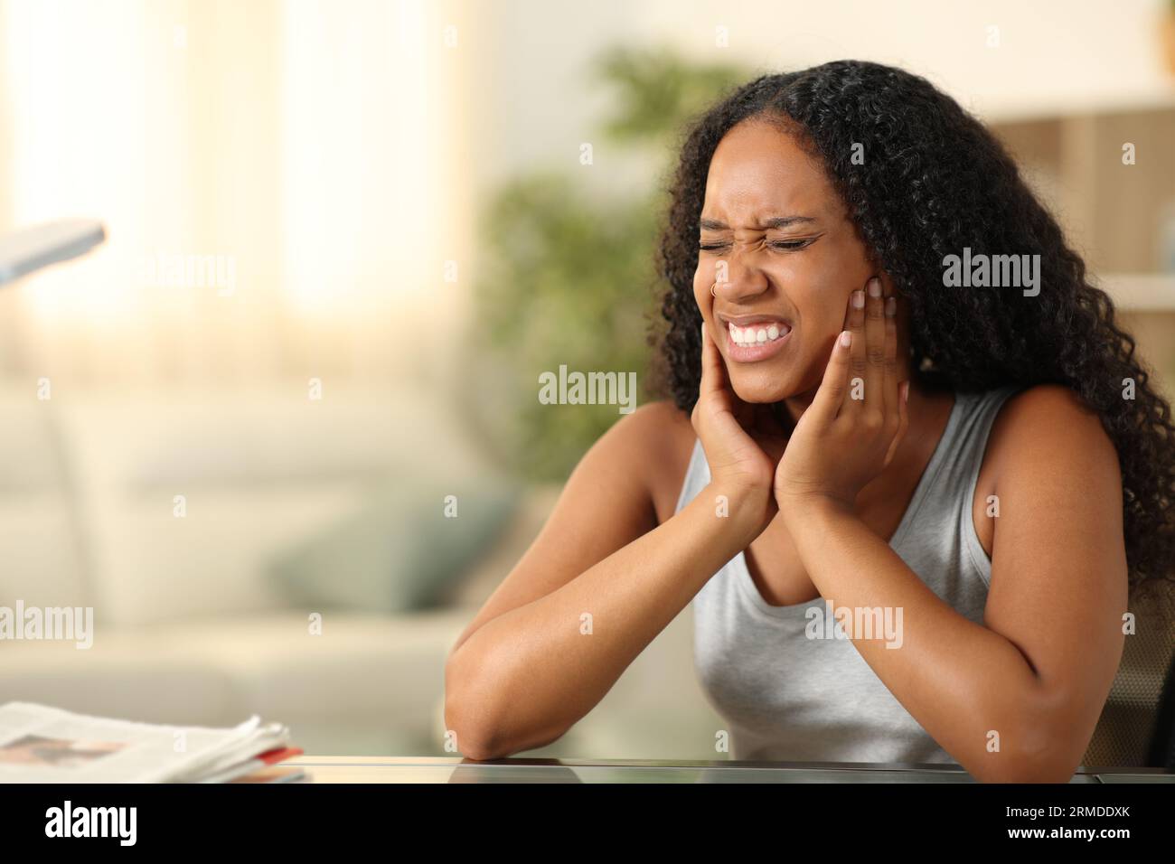 Black woman suffering tmj complaining sitting at home Stock Photo