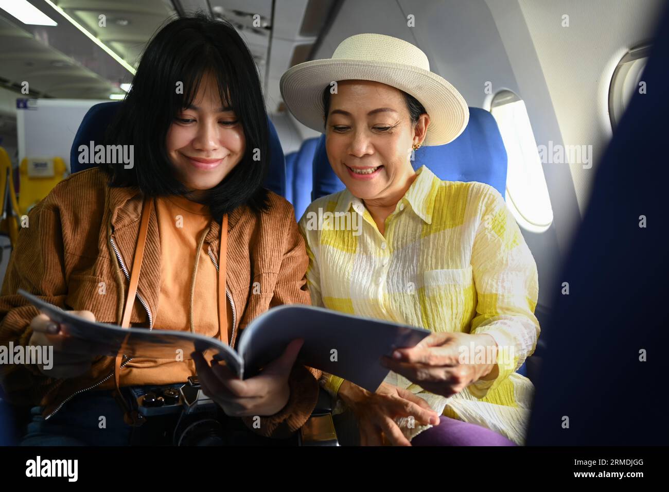 Happy Retried Woman And Daughter Sitting In Passenger Airplane And 