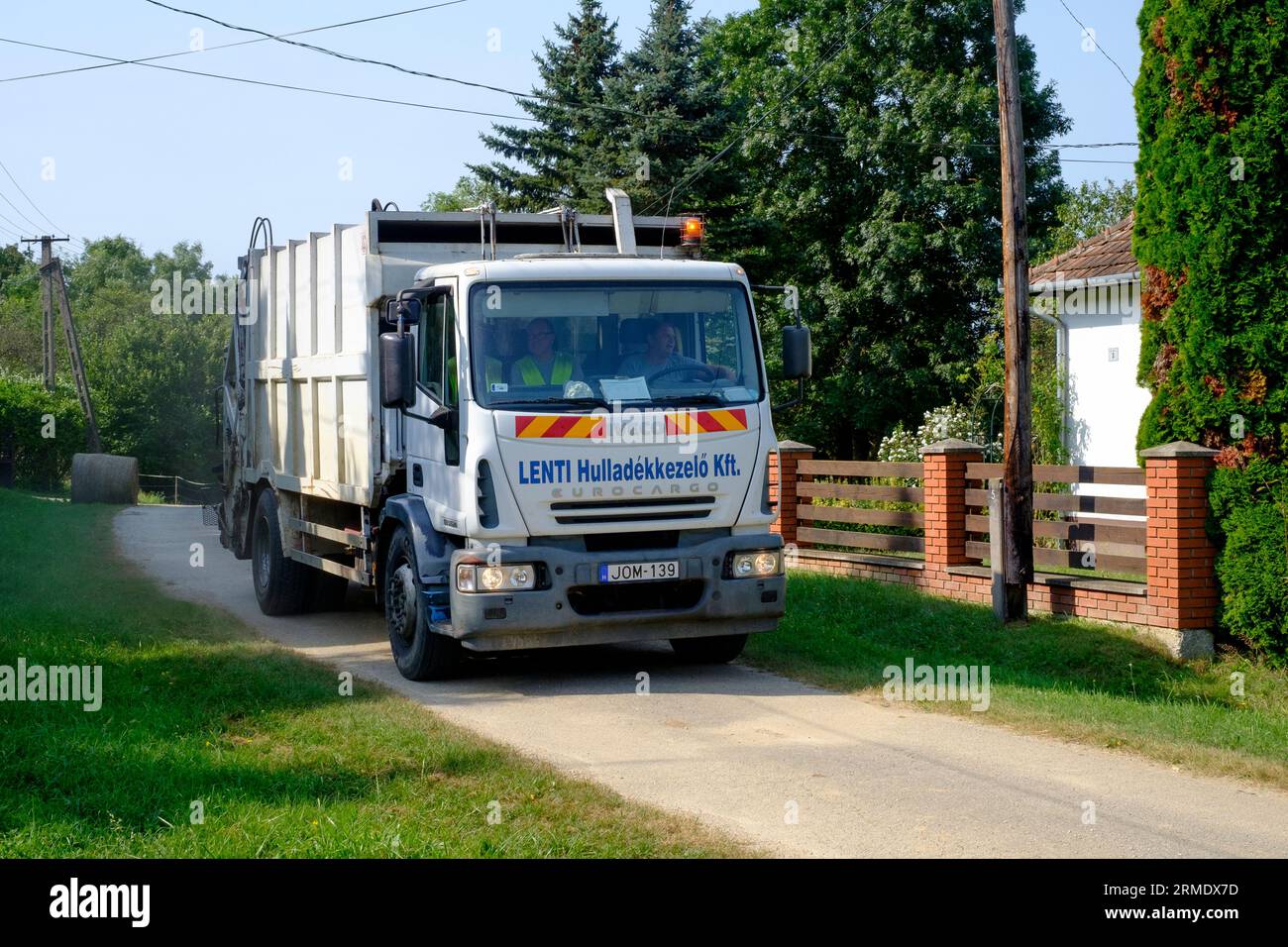 hungarian refuse truck lorry driving along rural village lane collecting household garbage hungary Stock Photo