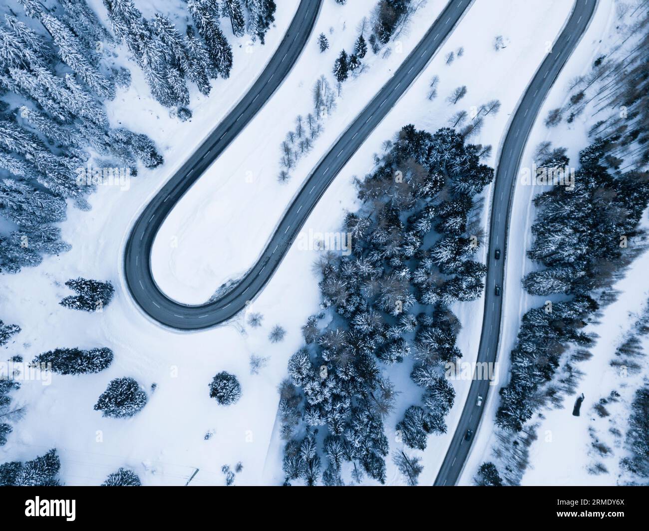 S-shape road and snowy woods from above, Maloja Pass, Switzerland Stock Photo