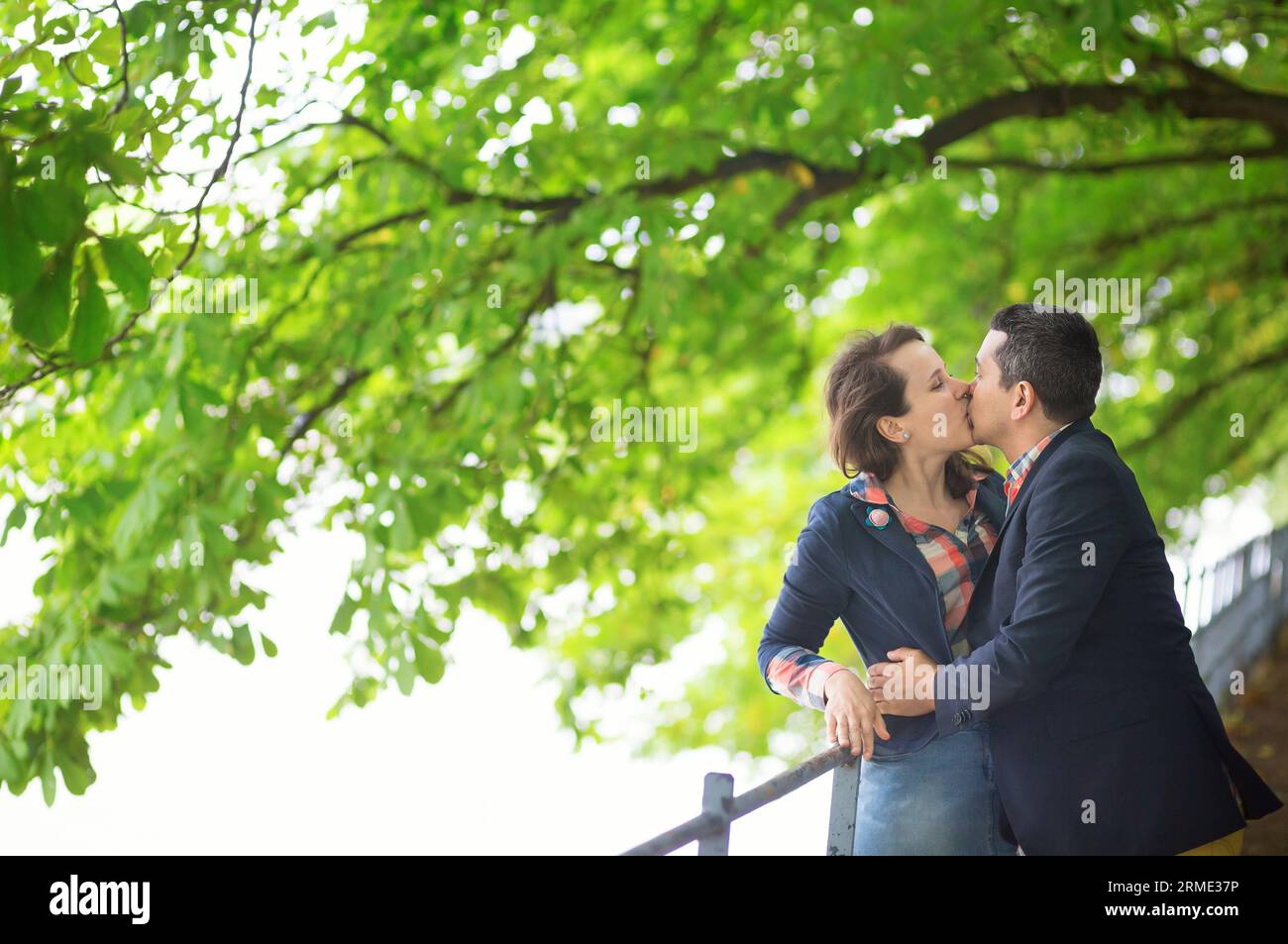 Couple kissing under a chestnut tree Stock Photo - Alamy