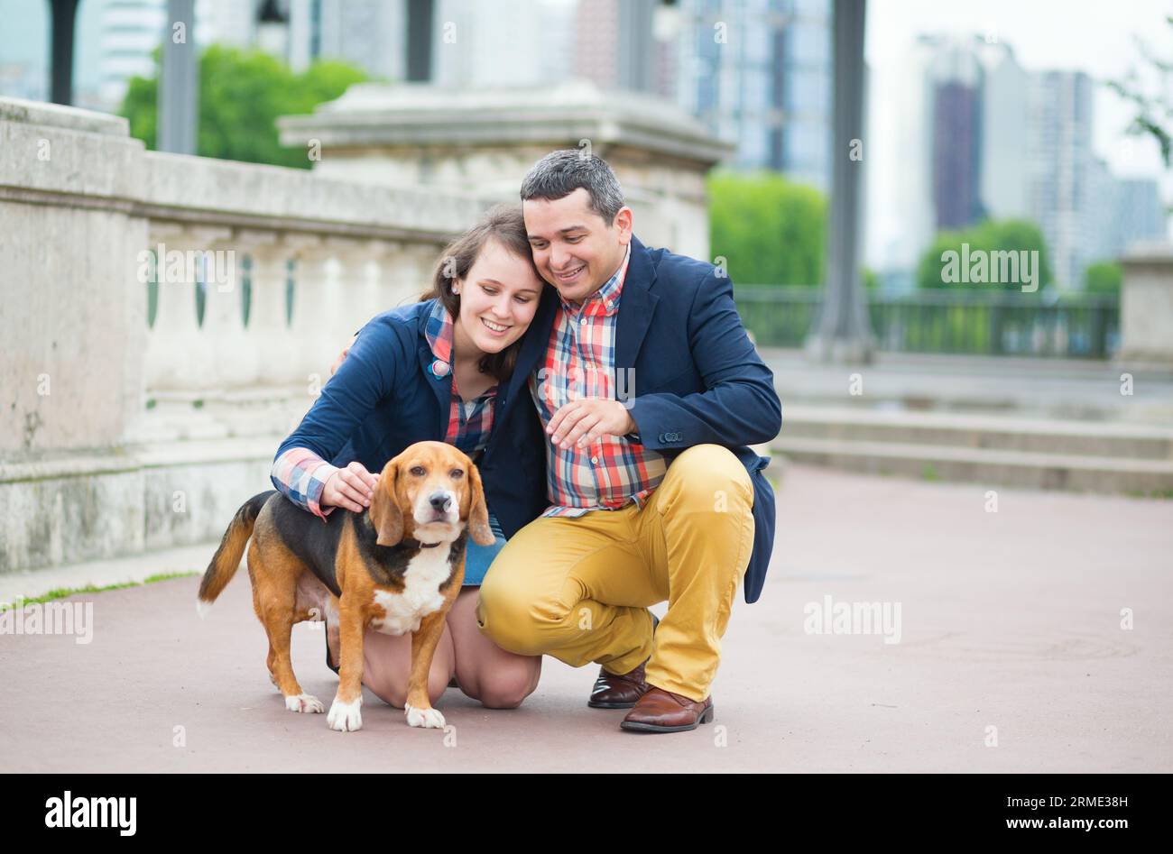 Couple walking with a dog in a city Stock Photo - Alamy