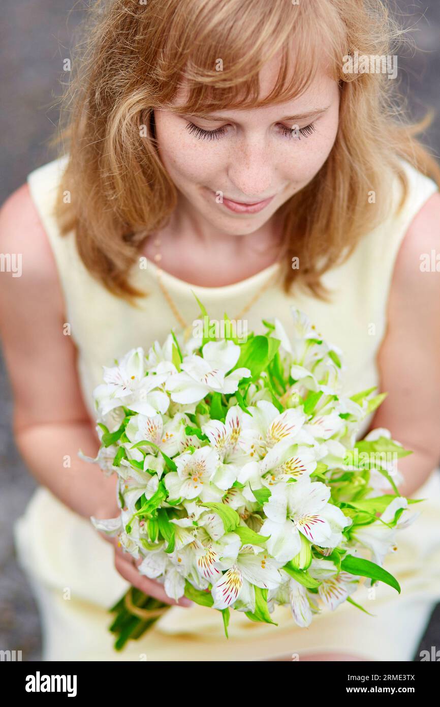 Young bride holding in her hands beautiful wedding flowers Stock Photo