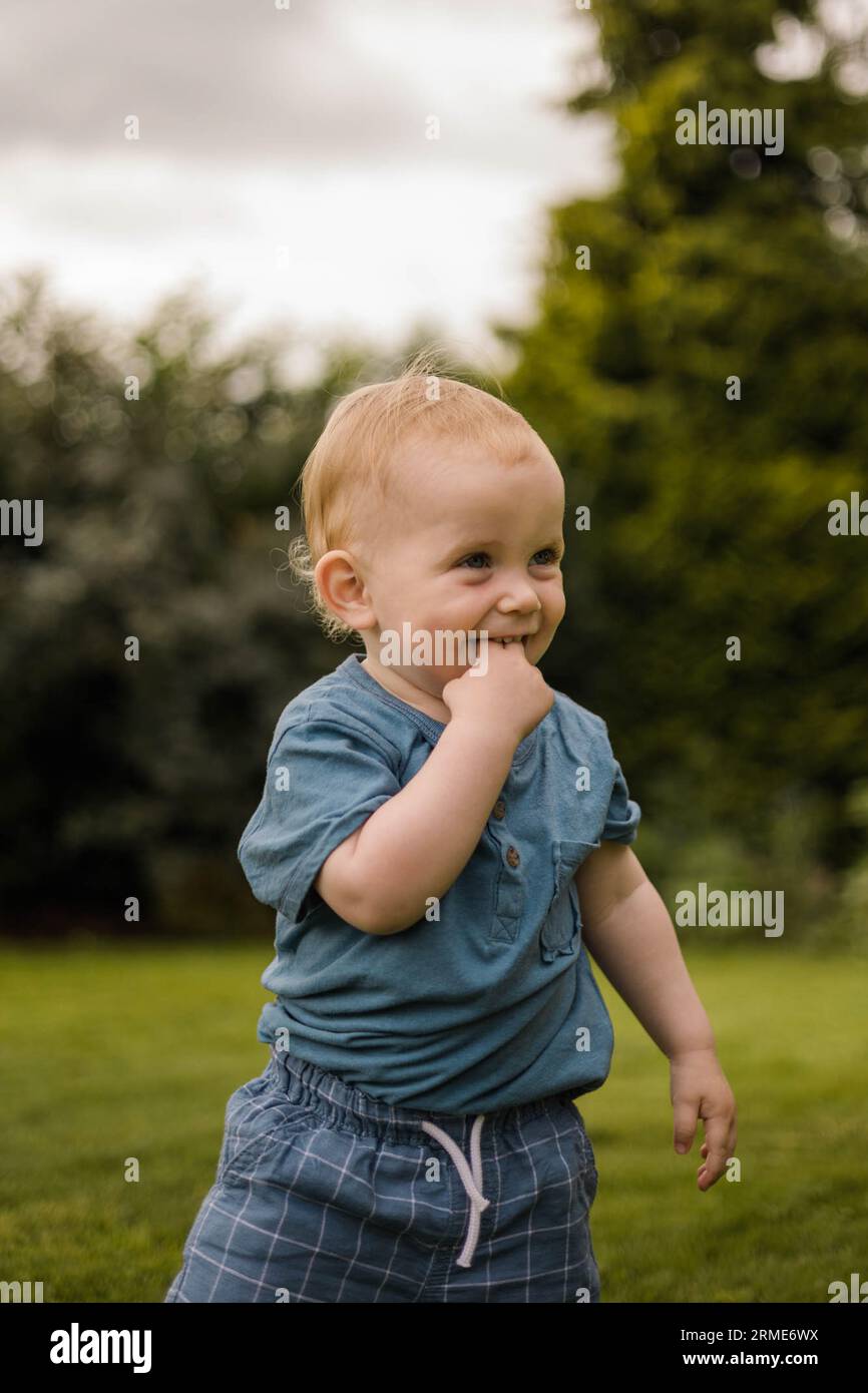 Cute toddler smiles and plays joyfully in the garden Stock Photo
