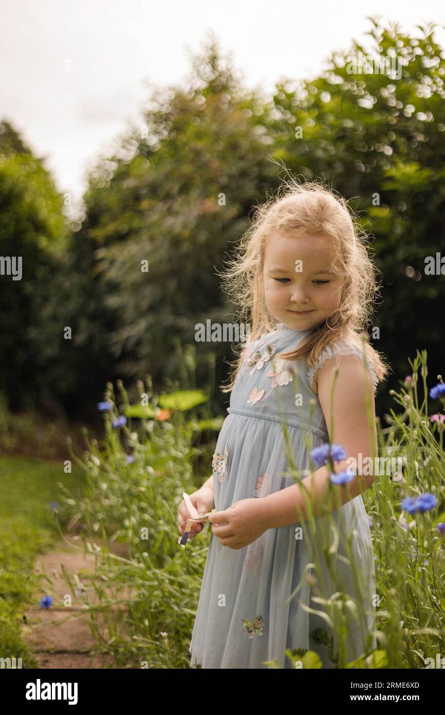 Young girl in butterfly dress amongst the wildflowers Stock Photo