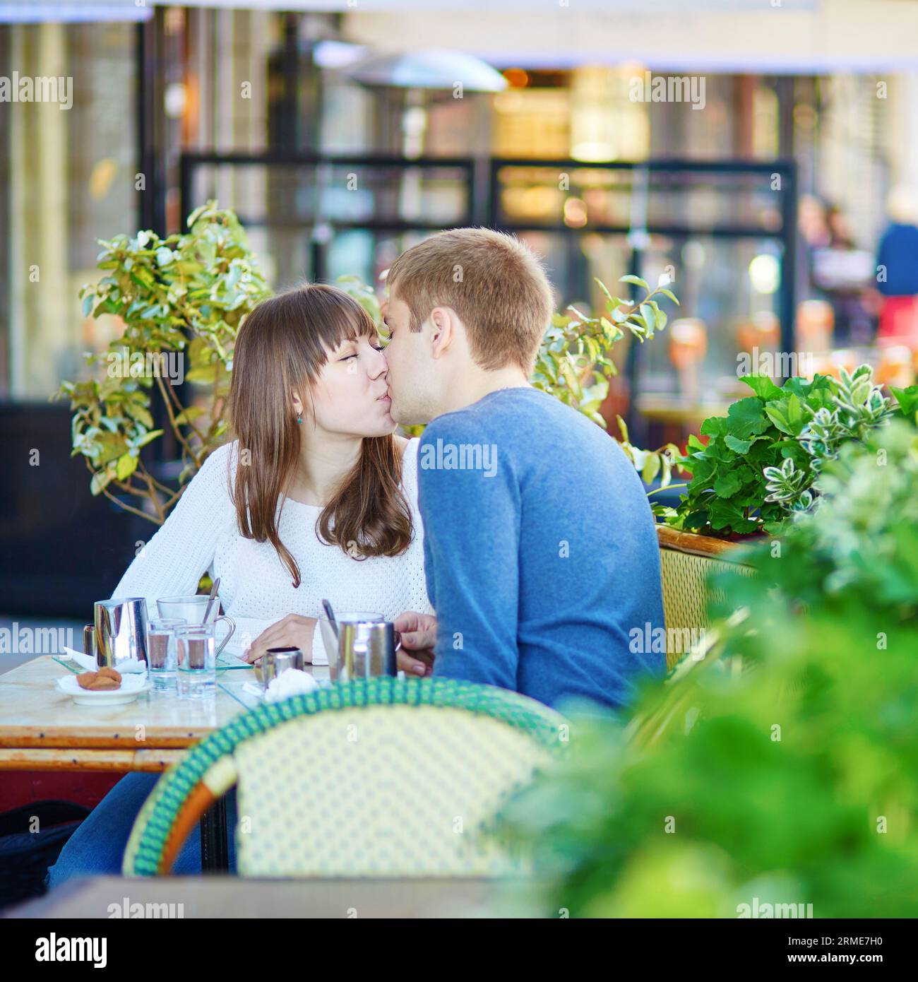 Young romantic couple having a date in a Parisian outdoor cafe