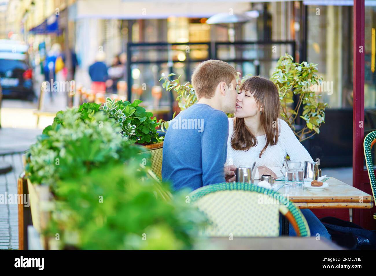 Young romantic couple having a date in a Parisian outdoor cafe