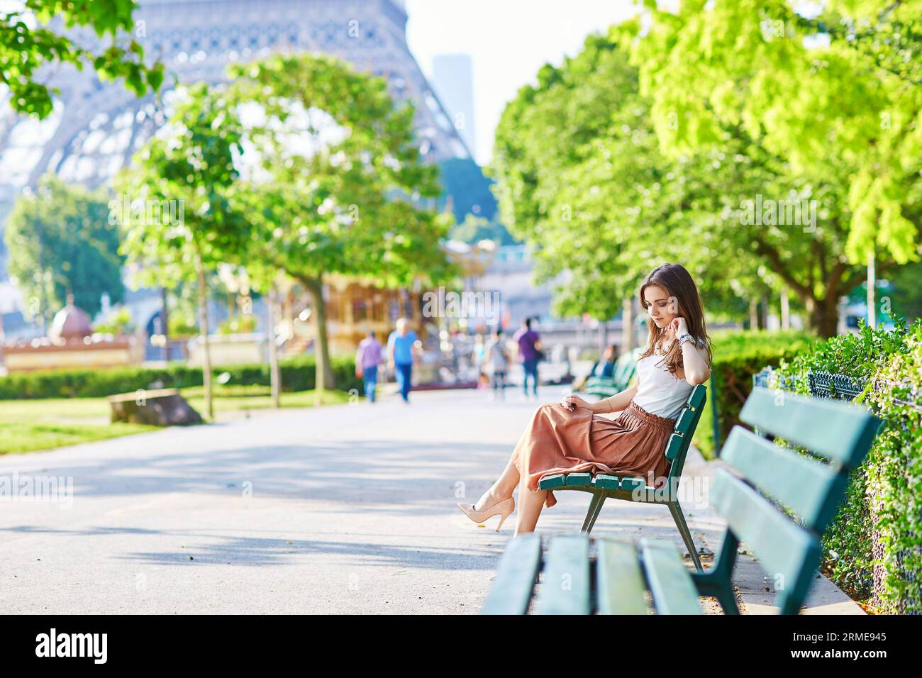 Attractive young woman wearing fancy universe print leggings sitting on a  bench in front of a small pond Stock Photo - Alamy
