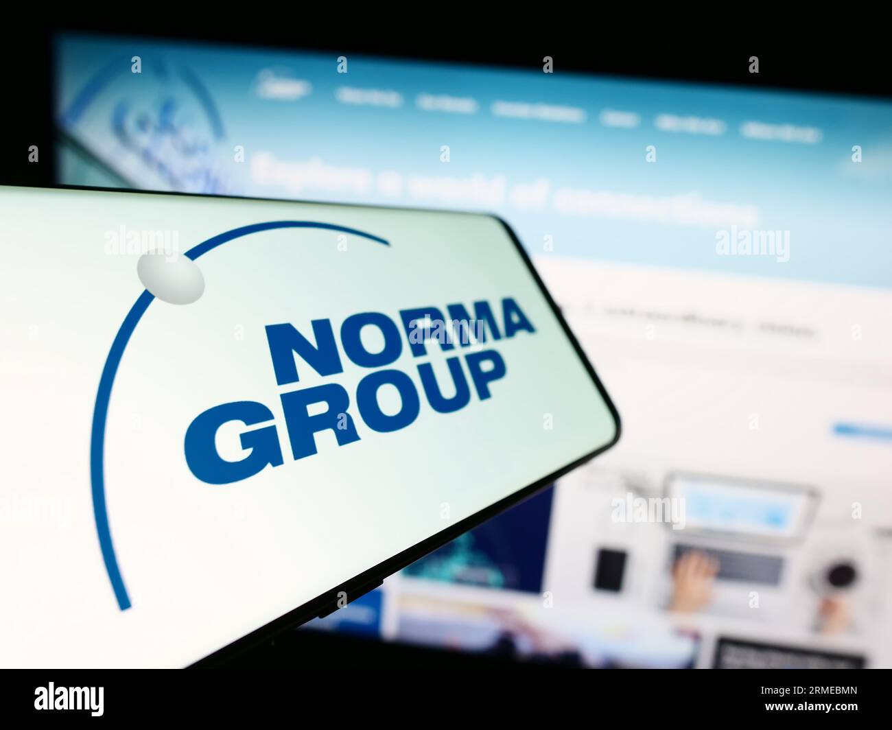 Mobile phone with logo of German manufacturing company Norma Group SE on screen in front of business website. Focus on left of phone display. Stock Photo